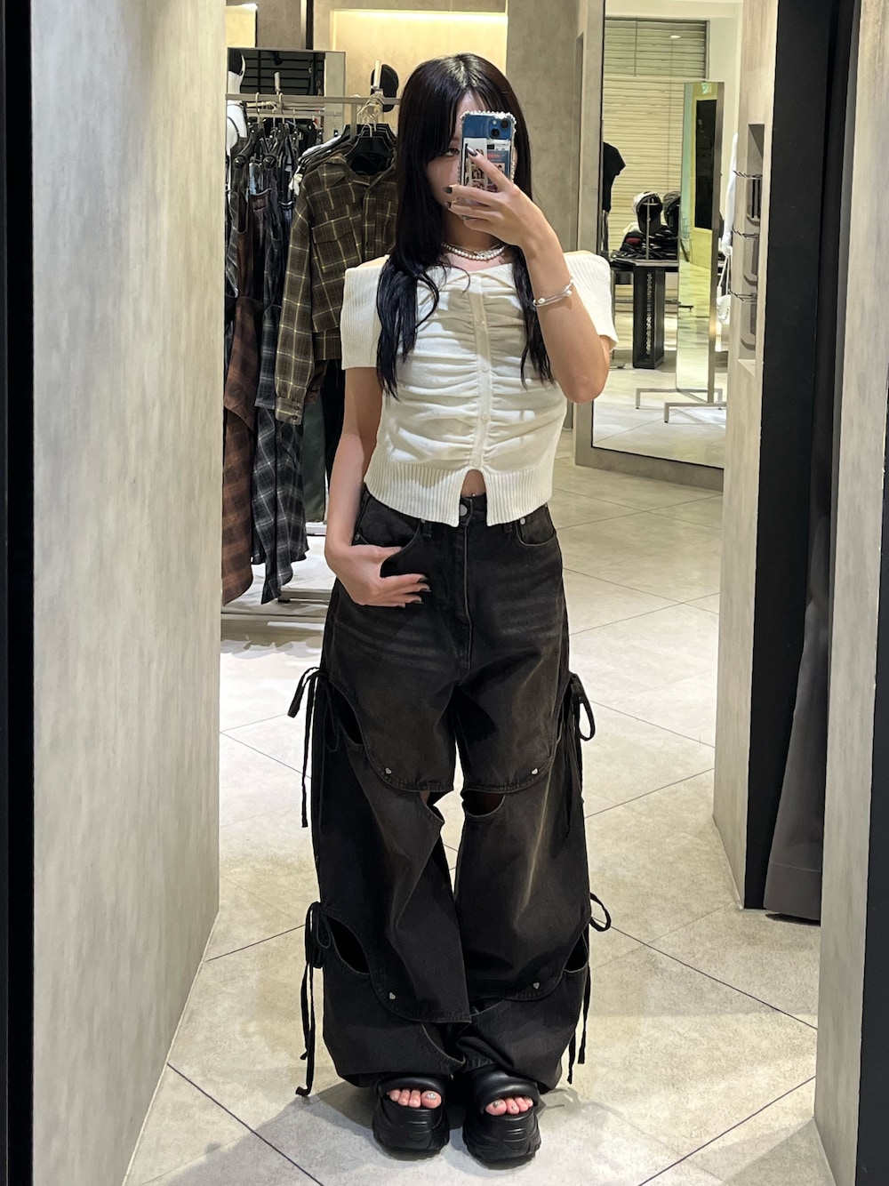 ホワイト系のニット/セーター、ブラック系のデニムパンツ、ブラック系のサンダルを着用したレディースの秋コーディネートの1枚目の写真