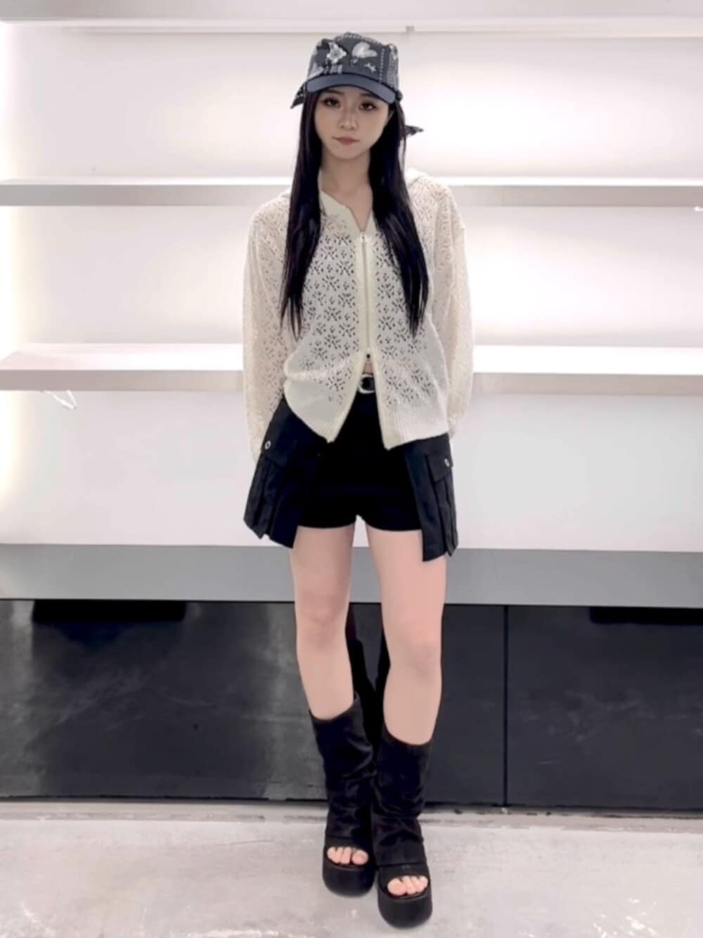 ブラック系のサンダル、ホワイト系のパーカー、ブラック系のスカートを着用したレディースの春コーディネートの1枚目の写真