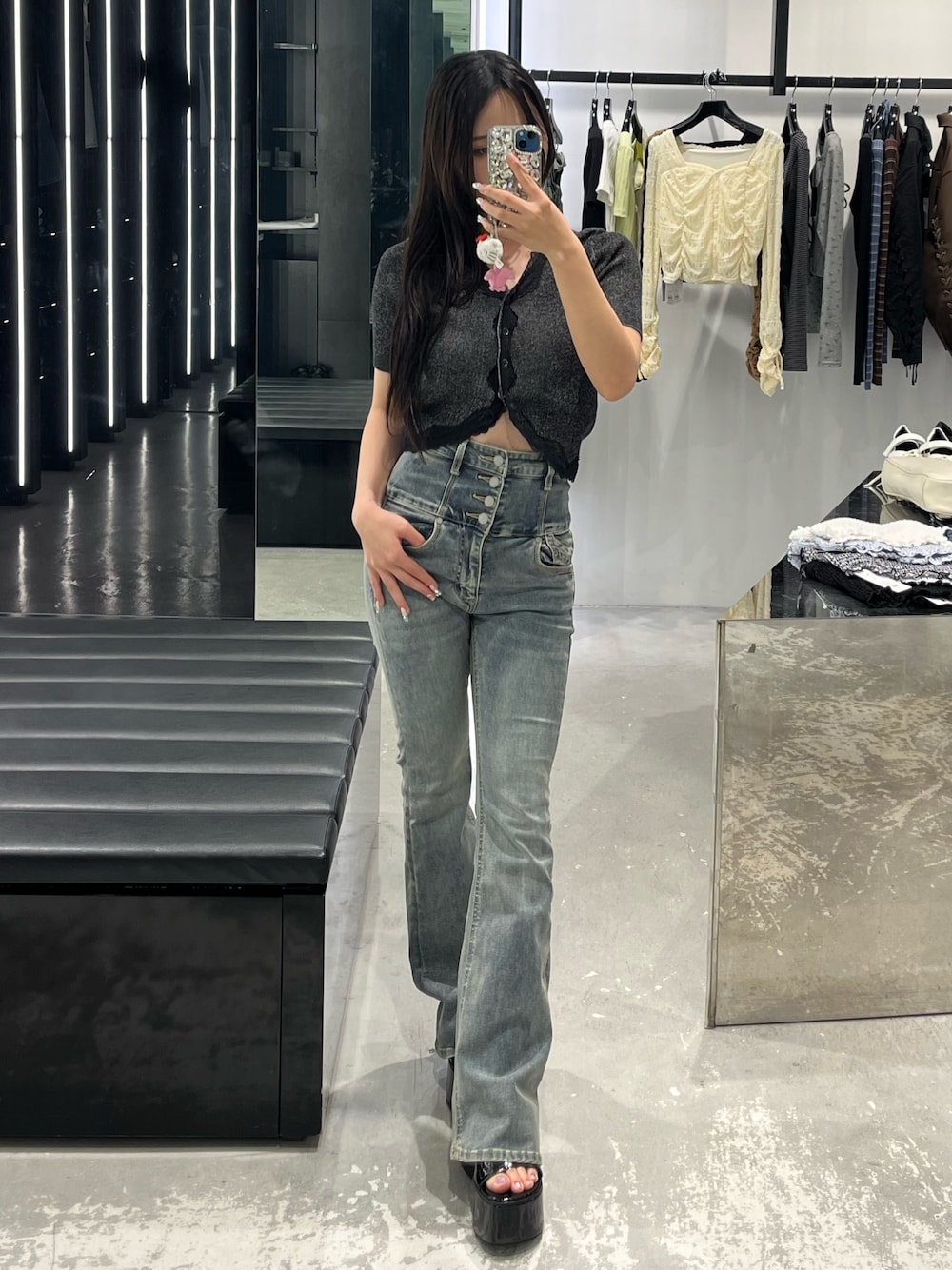 ブラック系のニット/セーター、ブルー系のデニムパンツ、ブラック系のサンダルを着用したレディースの春コーディネートの1枚目の写真