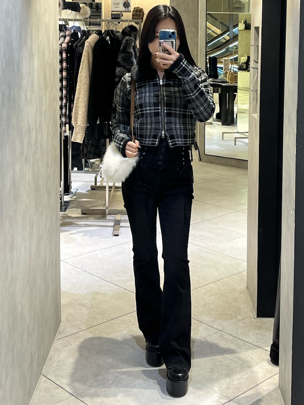 ブラック系のニット/セーター、ブラック系のデニムパンツ、ブラック系のブーツを着用したレディースの冬コーディネートの1枚目の写真