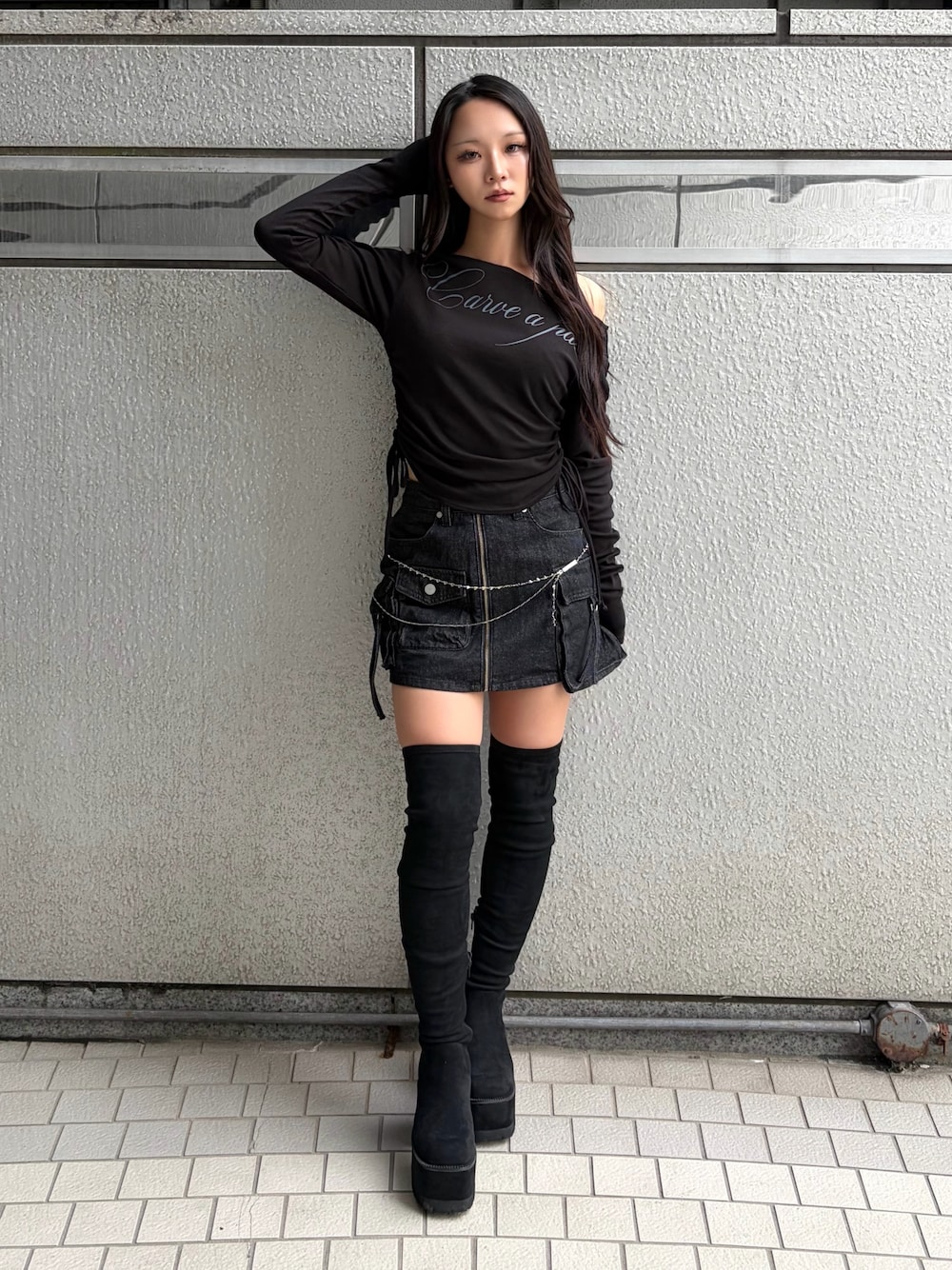 ブラック系のTシャツ/カットソー、ブラック系のスカート、ブラック系のブーツを着用したレディースの秋コーディネートの1枚目の写真