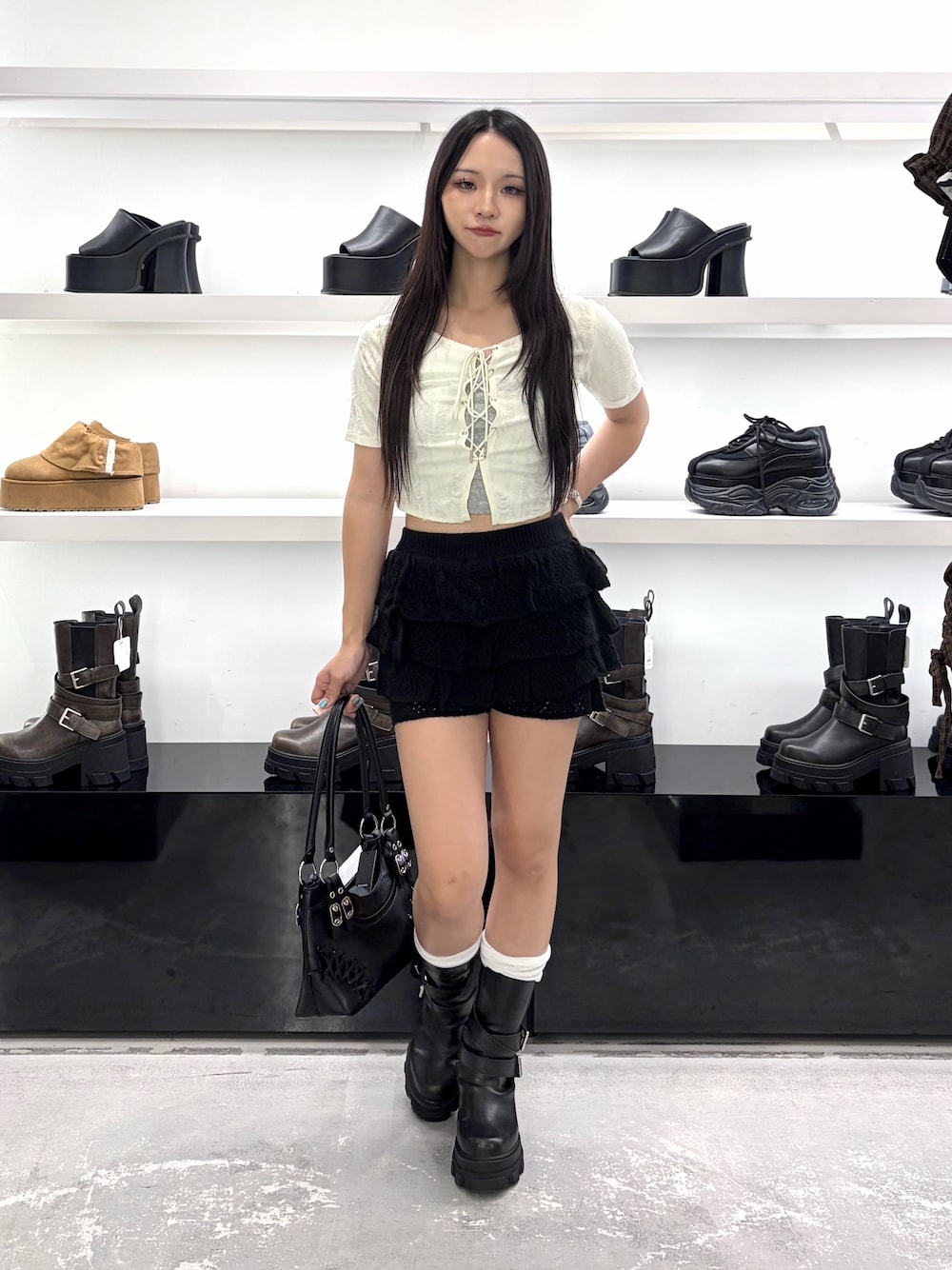ホワイト系のTシャツ/カットソー、ブラック系のスカート、ブラック系のブーツを着用したレディースの夏コーディネートの1枚目の写真