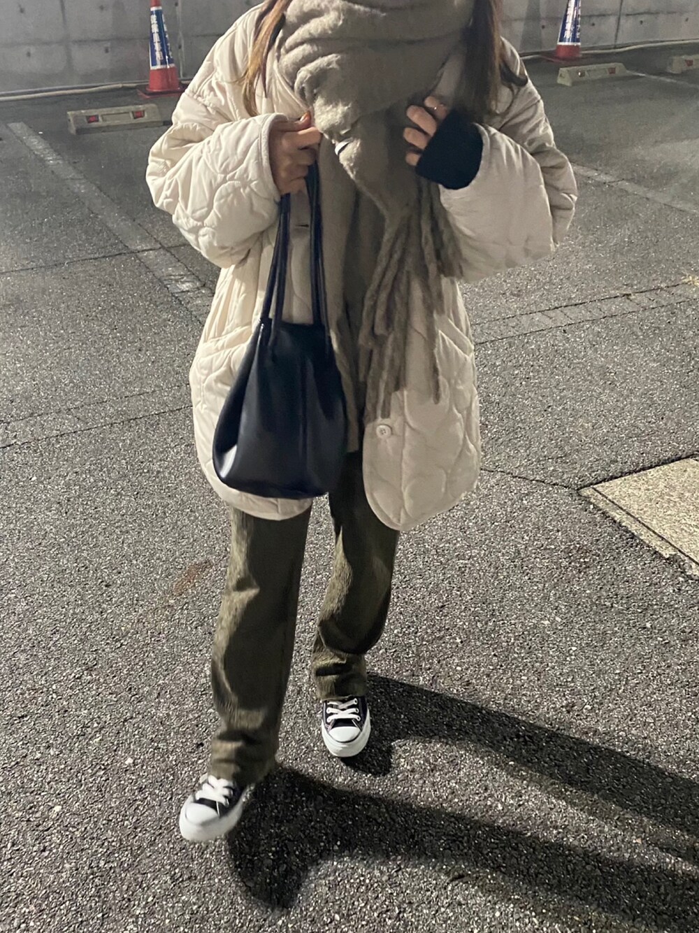 ホワイト系のノーカラージャケット、ブラック系のハンドバッグ、グリーン系のその他パンツを着用したレディースの冬コーディネートの1枚目の写真