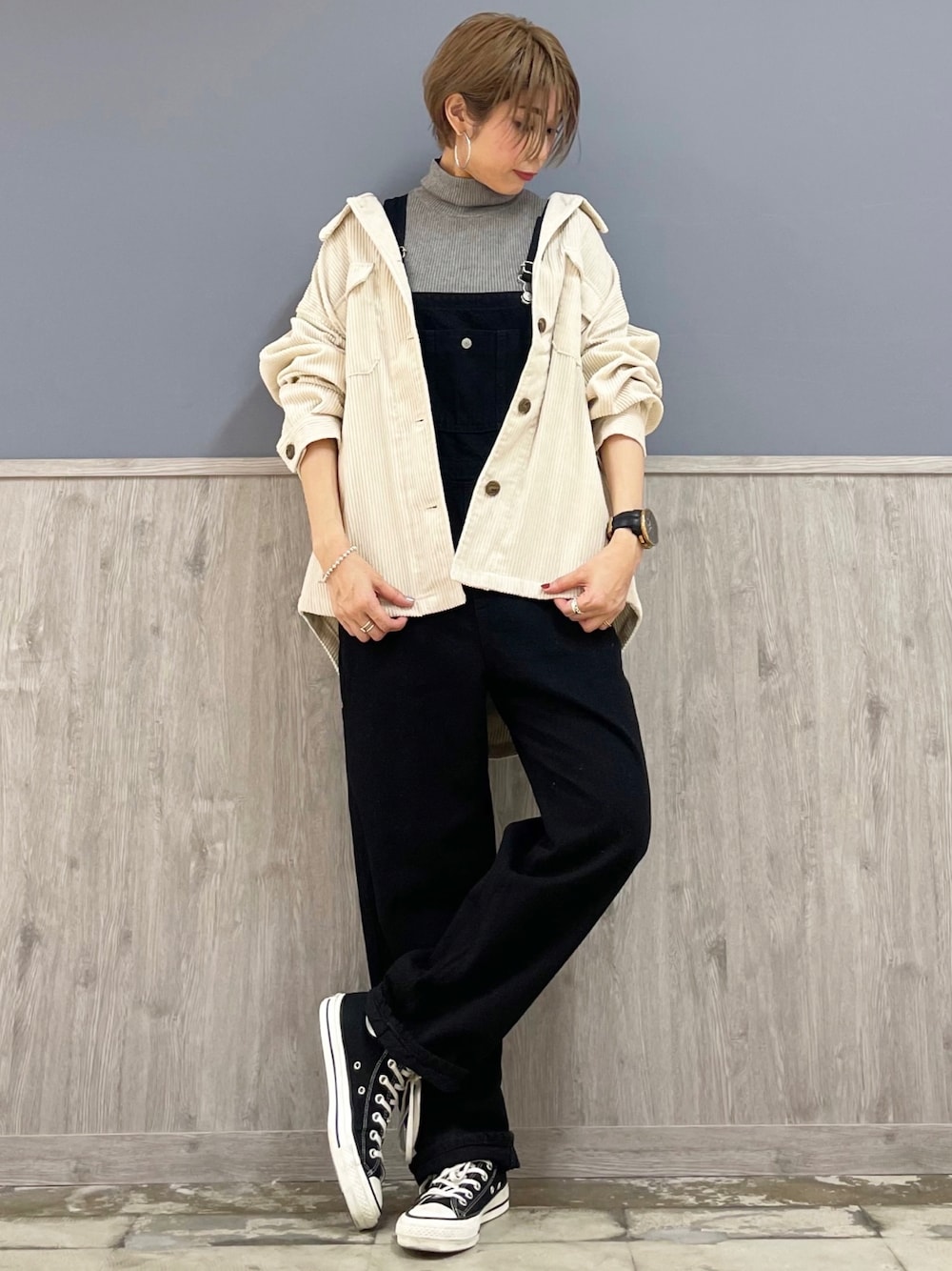 ブラック系のスニーカー、ブラック系のサロペット/オーバーオール、ホワイト系のシャツ/ブラウスを着用したレディースの秋コーディネートの1枚目の写真