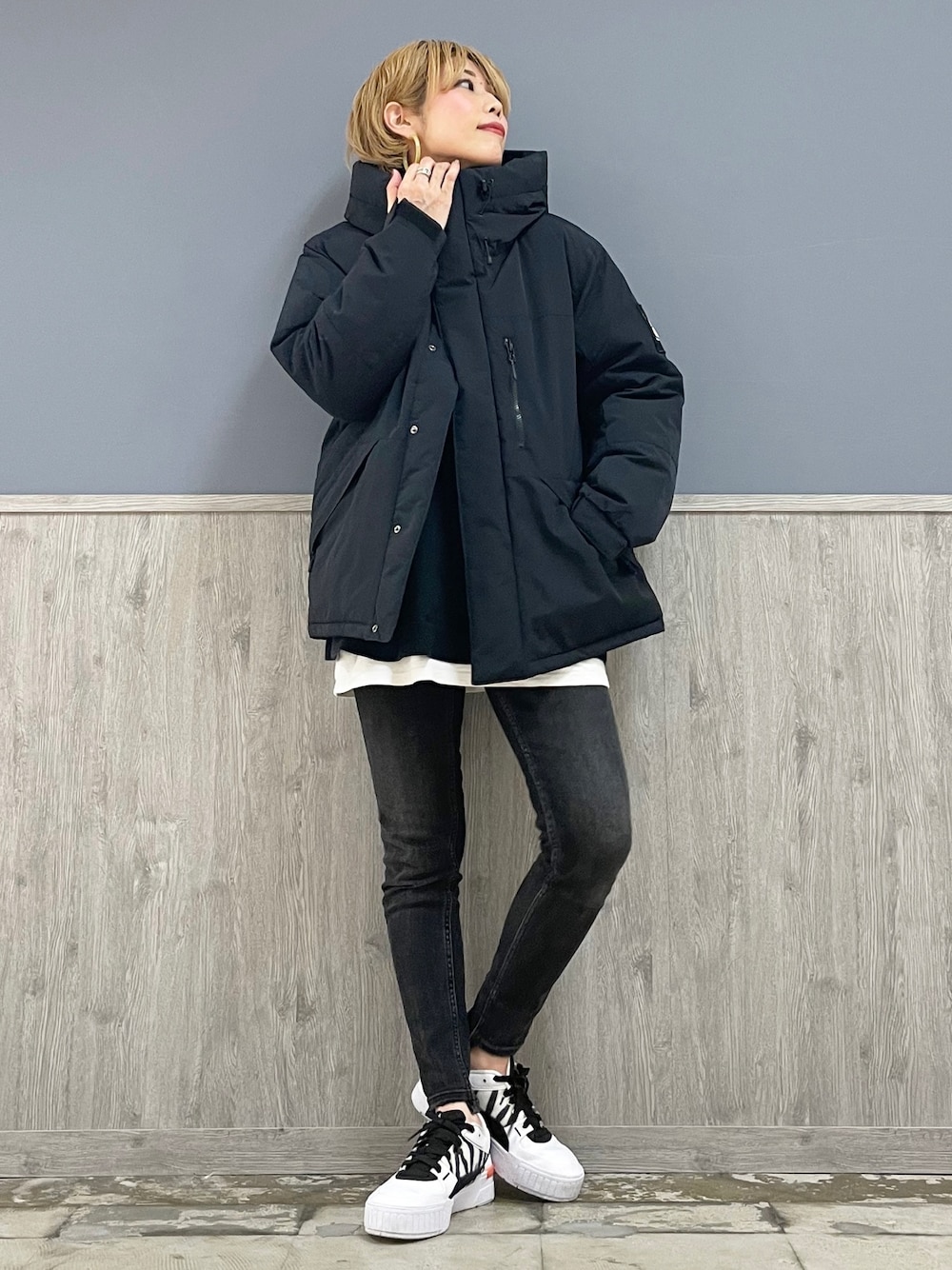 ブラック系のデニムパンツ、ブラック系のダウンジャケット/コート、ホワイト系のTシャツ/カットソーを着用したレディースの秋コーディネートの1枚目の写真