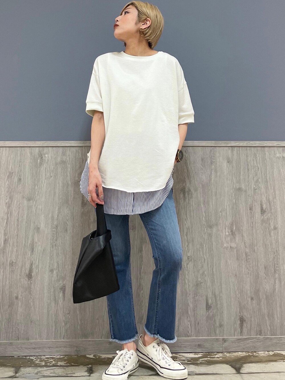 ブルー系のデニムパンツ、ホワイト系のトップス、ブルー系のタンクトップを着用したレディースの春コーディネートの1枚目の写真