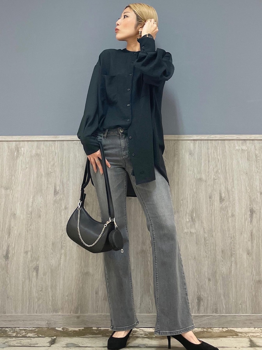 グレー系のデニムパンツ、ブラック系のショルダーバッグ、ブラック系のシャツ/ブラウスを着用したレディースの春コーディネートの1枚目の写真