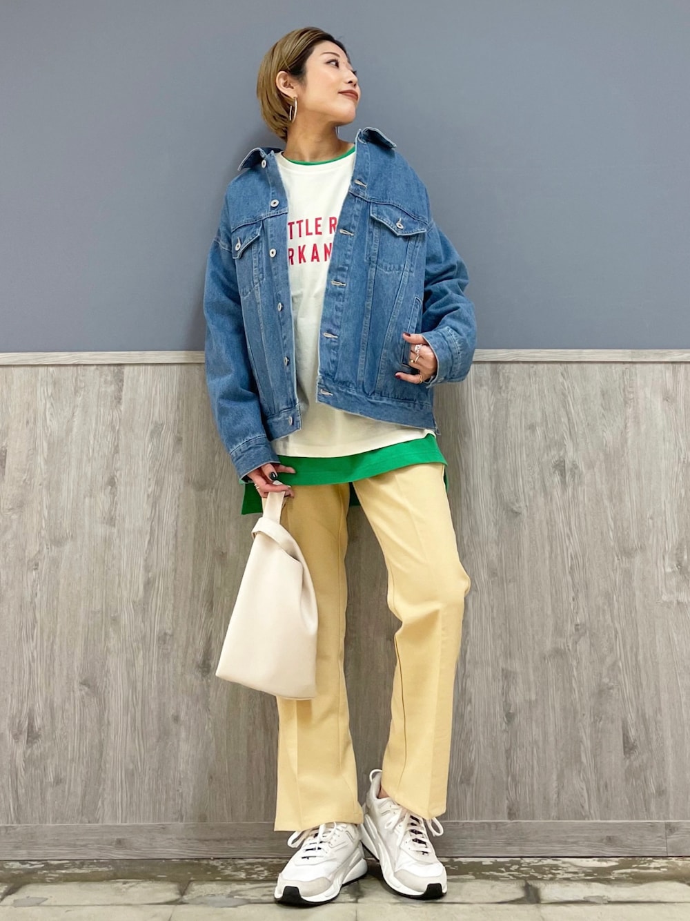 ホワイト系のショルダーバッグ、ブルー系のデニムジャケット、ホワイト系のTシャツ/カットソーを着用したレディースの冬コーディネートの1枚目の写真