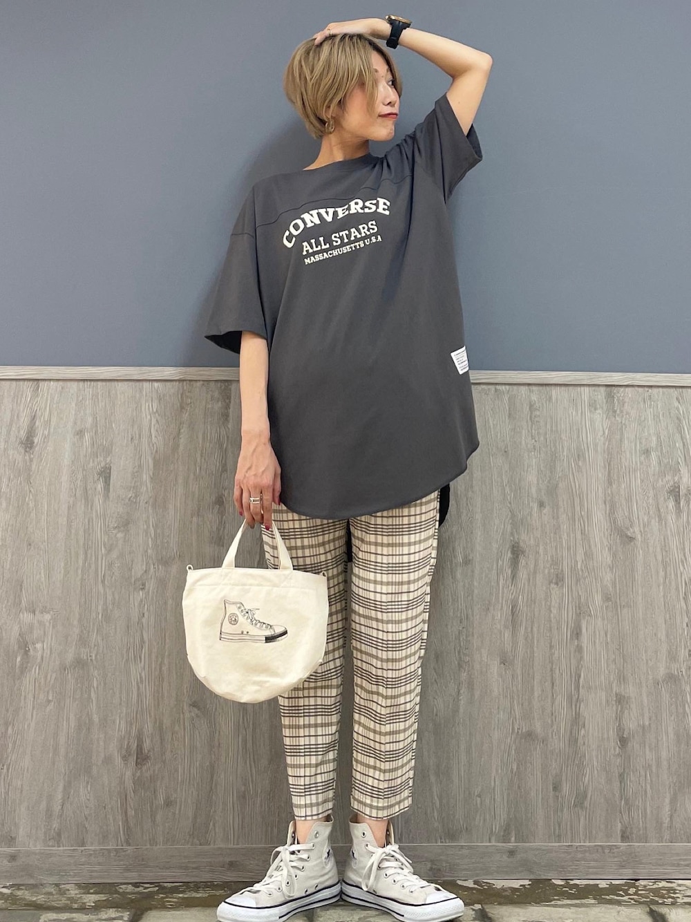グレー系のトップス、ホワイト系のスラックス、ホワイト系のショルダーバッグを着用したレディースの夏コーディネートの1枚目の写真