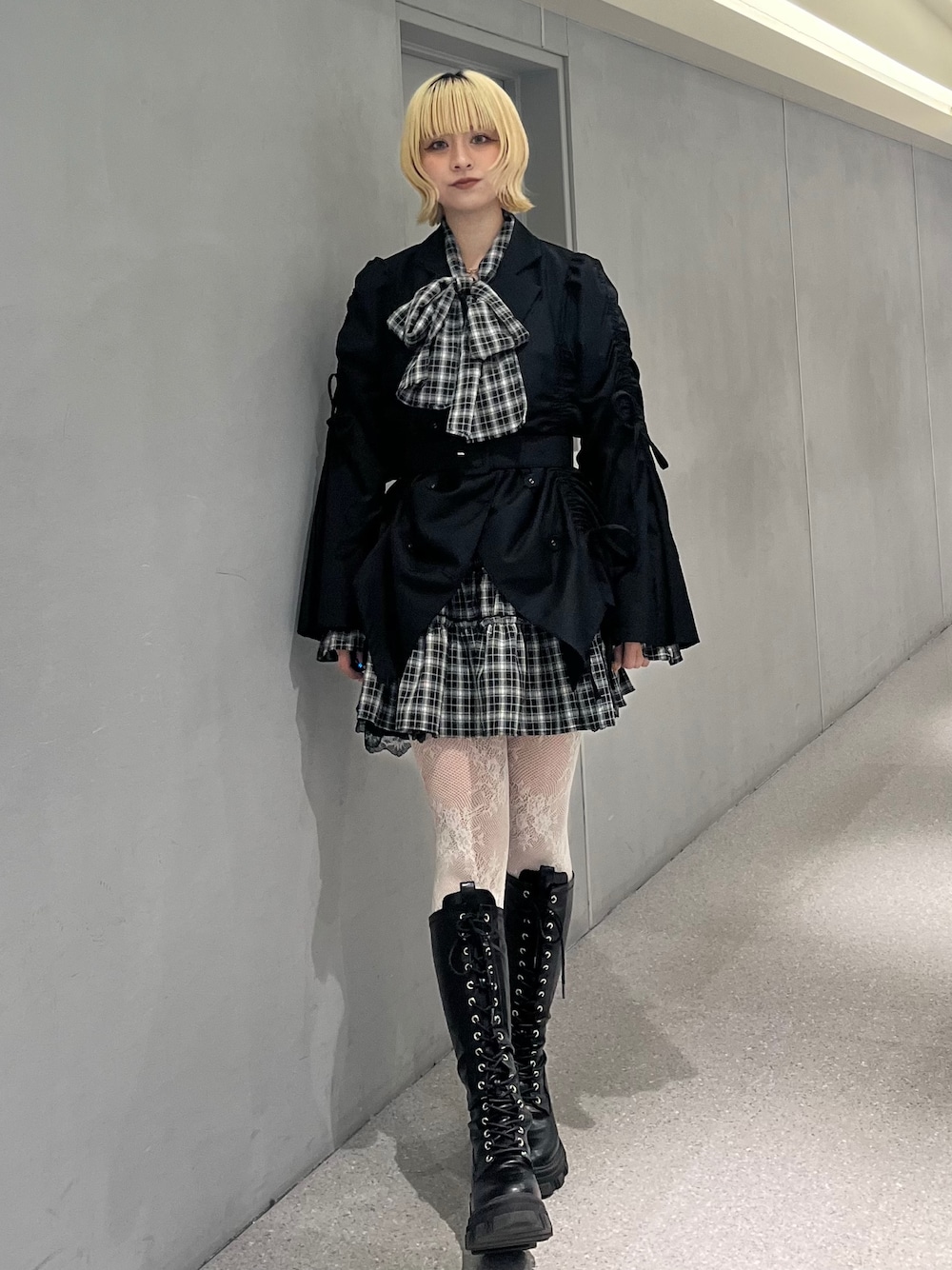 ブラック系のテーラードジャケット、ブラック系のワンピース、ブラック系のブーツを着用したレディースの冬コーディネートの1枚目の写真