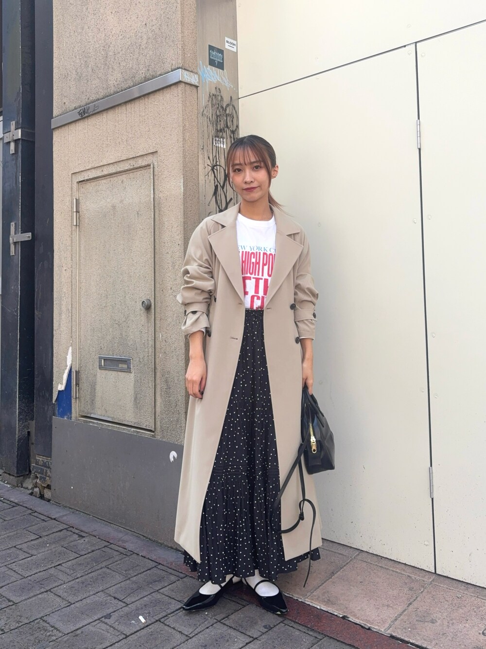 ベージュ系のトレンチコート、ホワイト系のTシャツ/カットソー、ブラック系のパンプスを着用したレディースの春コーディネートの1枚目の写真