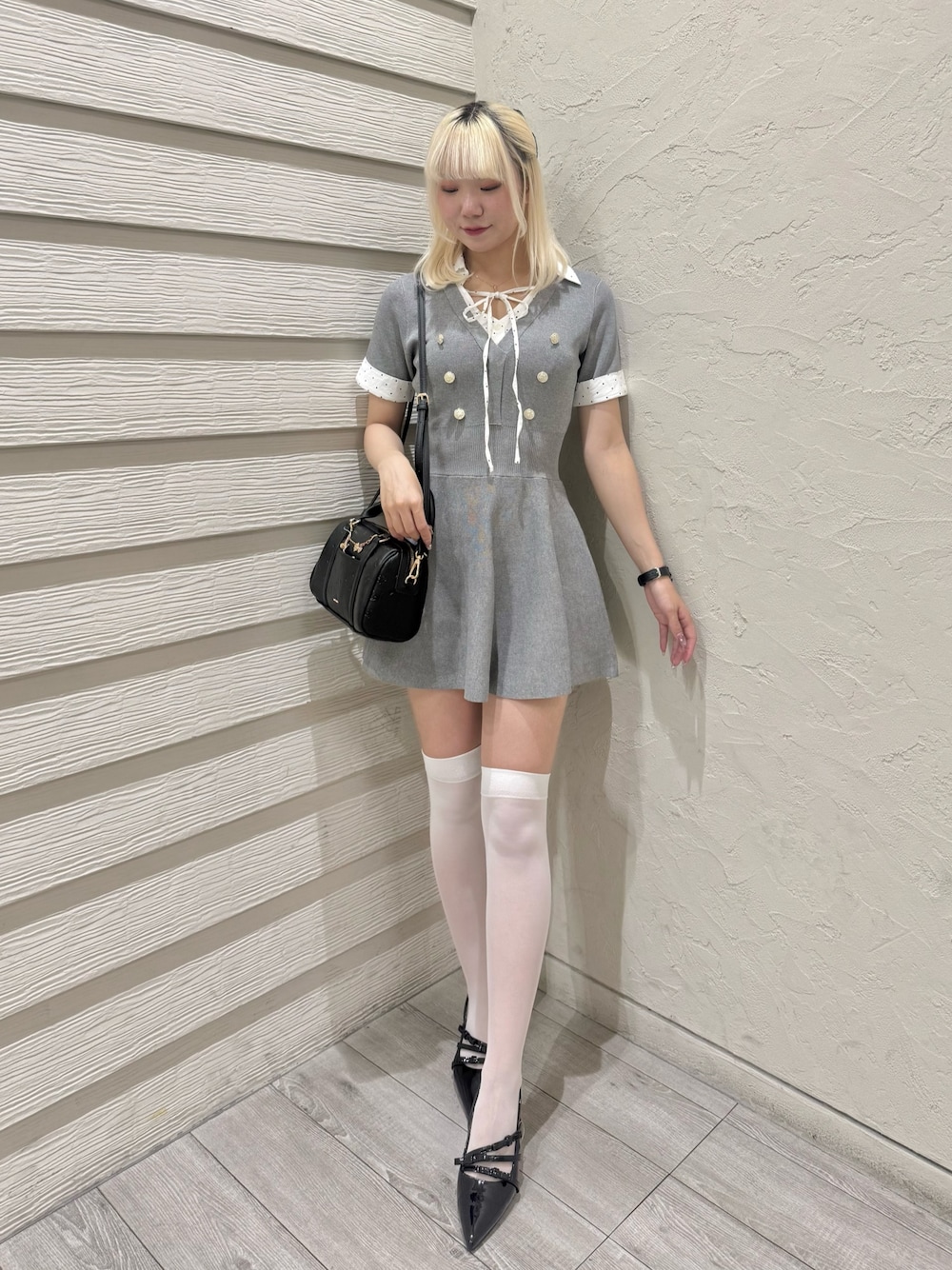 ブラック系のパンプス、ブラック系のショルダーバッグ、グレー系のワンピースを着用したレディースの夏コーディネートの1枚目の写真