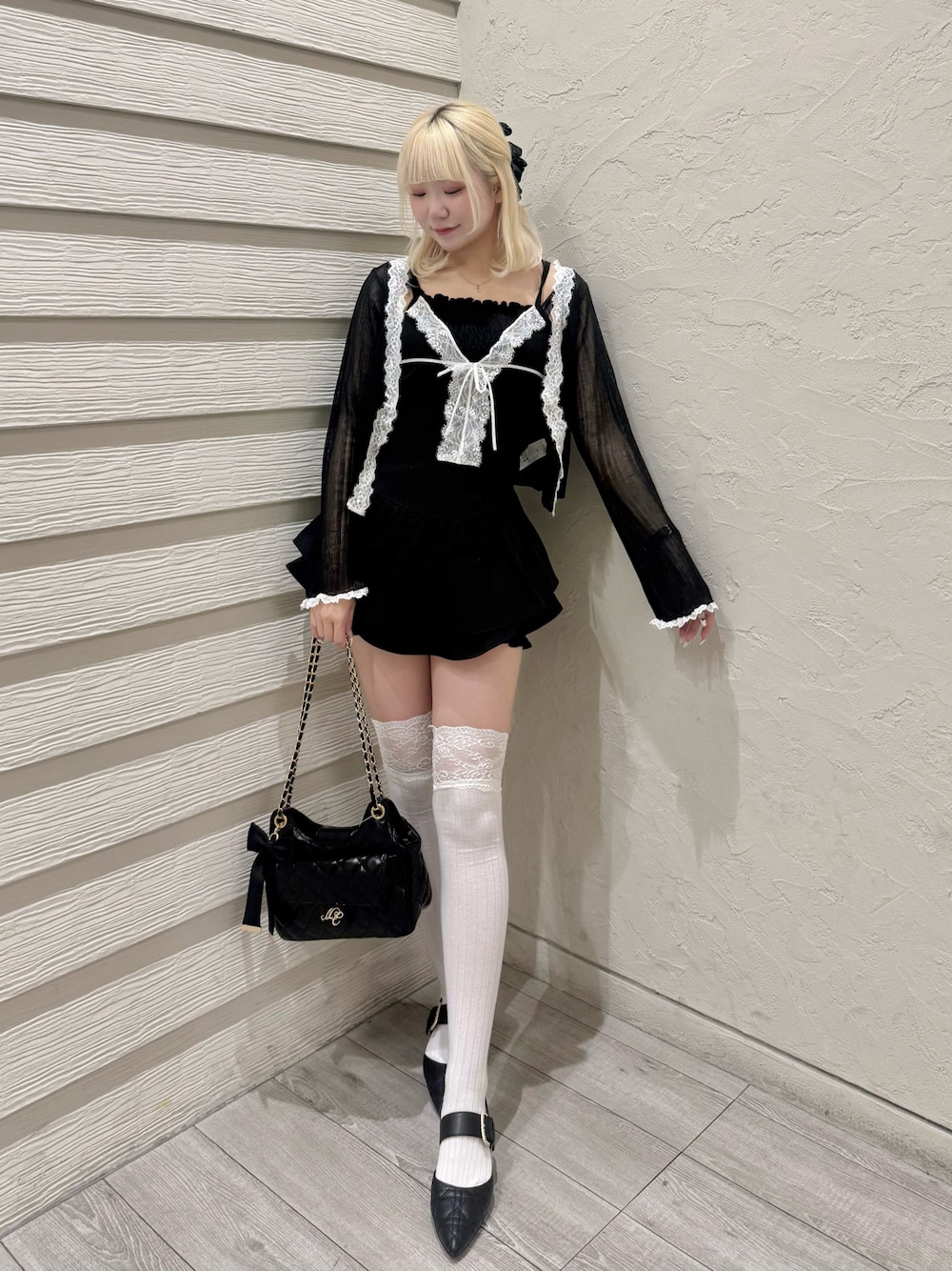 ブラック系のカーディガン/ボレロ、ブラック系のニット/セーター、ブラック系のショルダーバッグを着用したレディースの春コーディネートの1枚目の写真