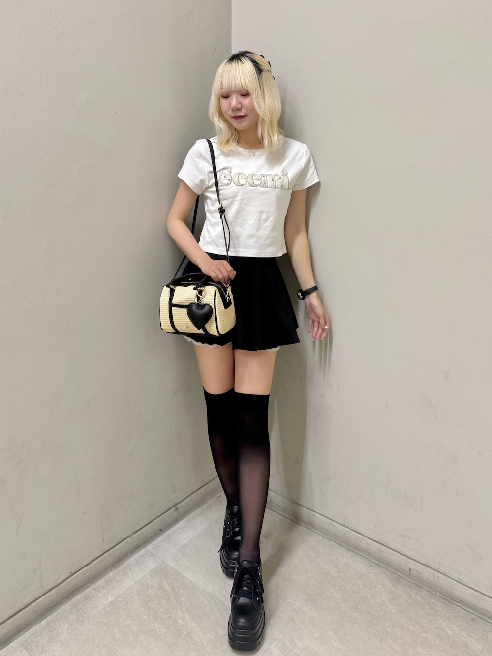 ブラック系のスニーカー、ホワイト系のTシャツ/カットソー、ブラック系のショルダーバッグを着用したレディースの夏コーディネートの1枚目の写真