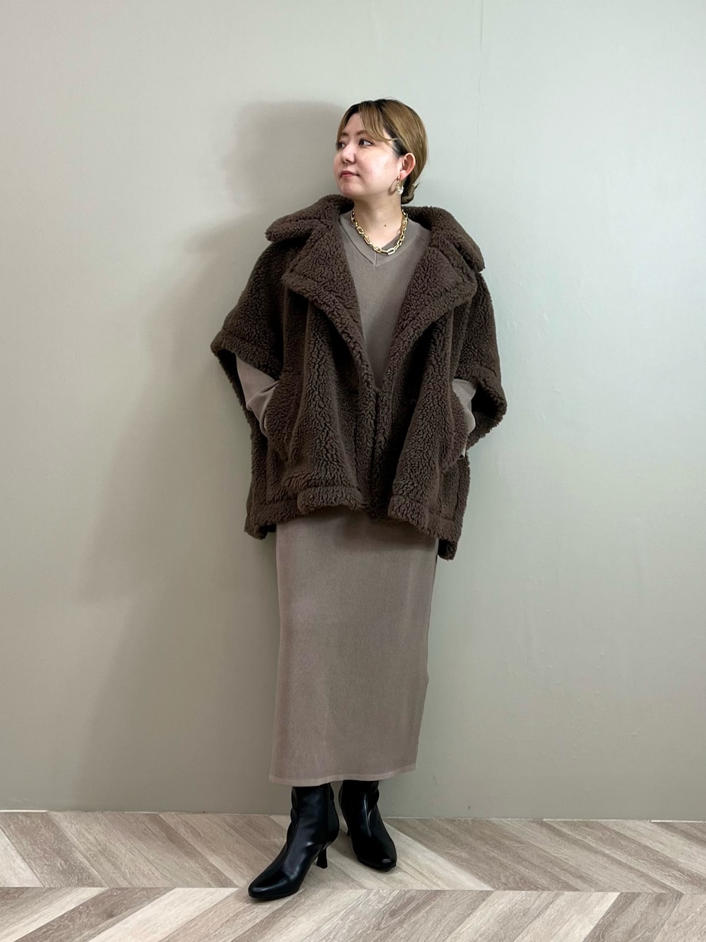 ブラウン系のその他アウター、ブラウン系のワンピース、ブラック系のブーツを着用したレディースの秋コーディネートの1枚目の写真