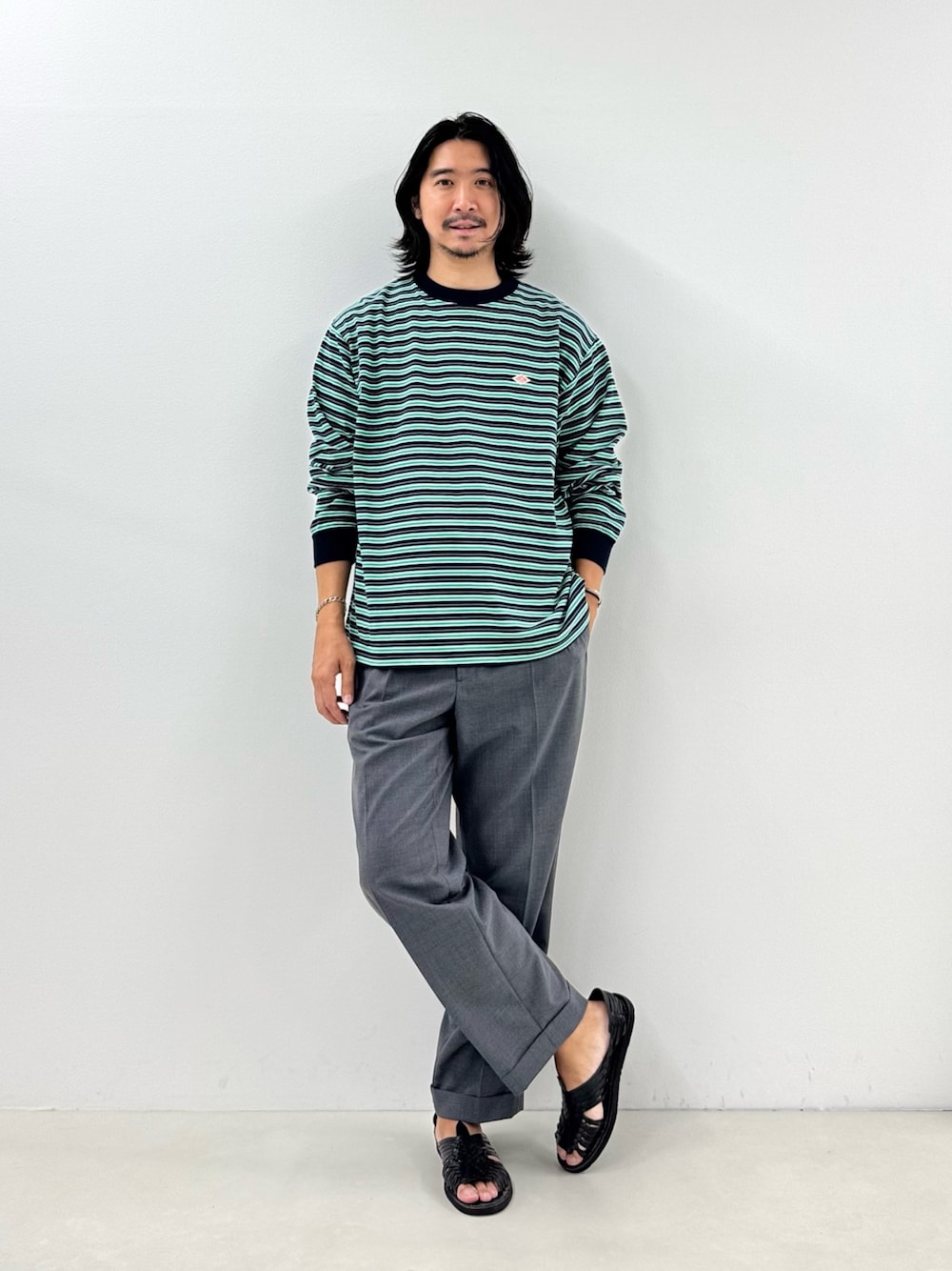 ブルー系のTシャツ/カットソー、グレー系のスラックスを着用したメンズの秋コーディネートの1枚目の写真