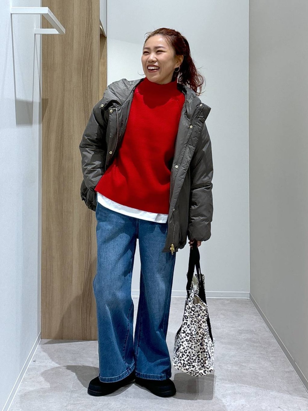 ブラウン系のダウンジャケット/コート、ホワイト系のTシャツ/カットソー、レッド系のニット/セーターを着用したレディースの秋コーディネートの1枚目の写真