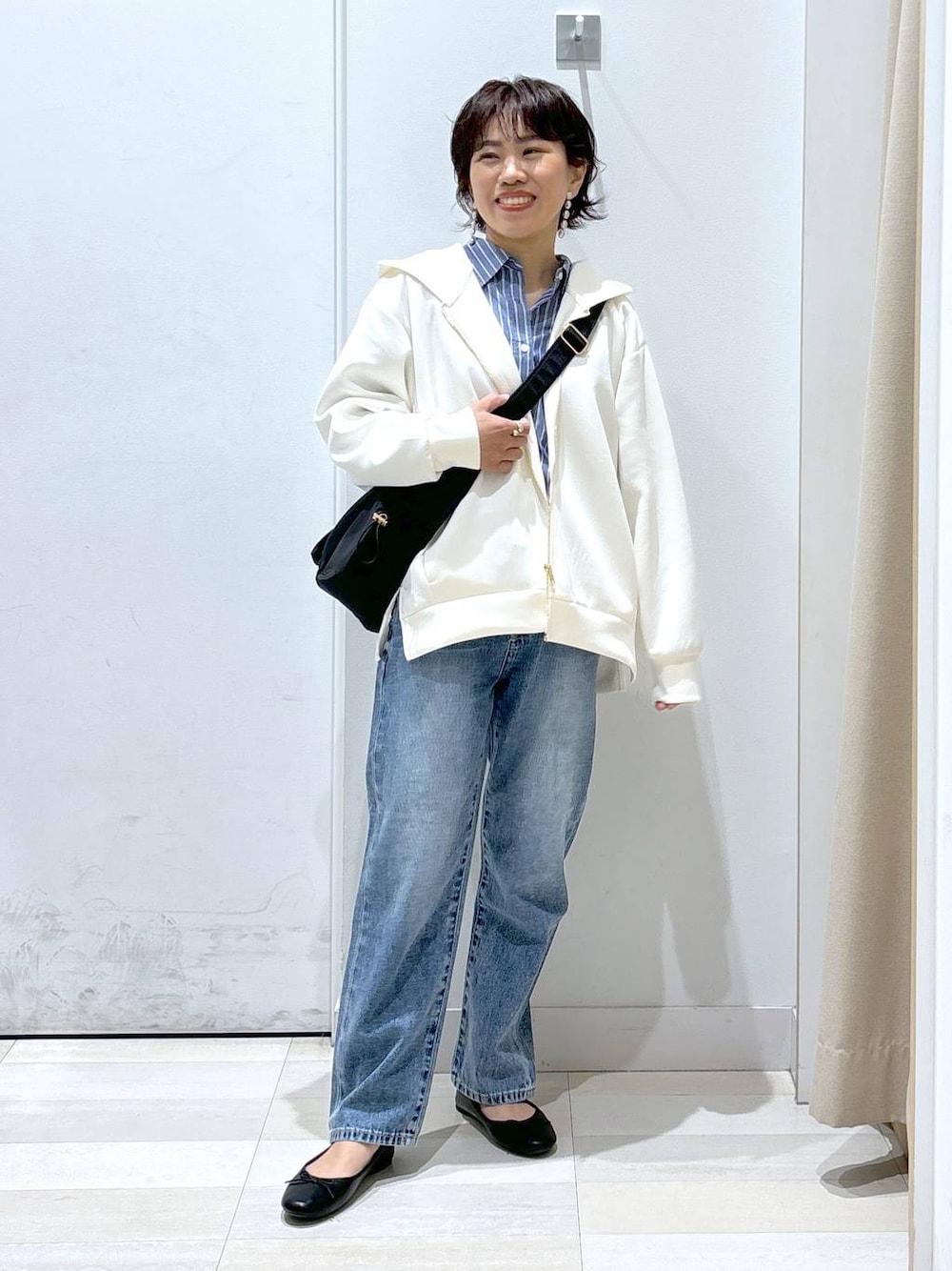 ブラック系のショルダーバッグ、ブルー系のデニムパンツ、その他のバレエシューズを着用したレディースの春コーディネートの1枚目の写真