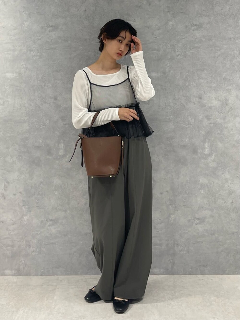 ブラウン系のトートバッグ、ブラック系のTシャツ/カットソーを着用したレディースの秋コーディネートの1枚目の写真