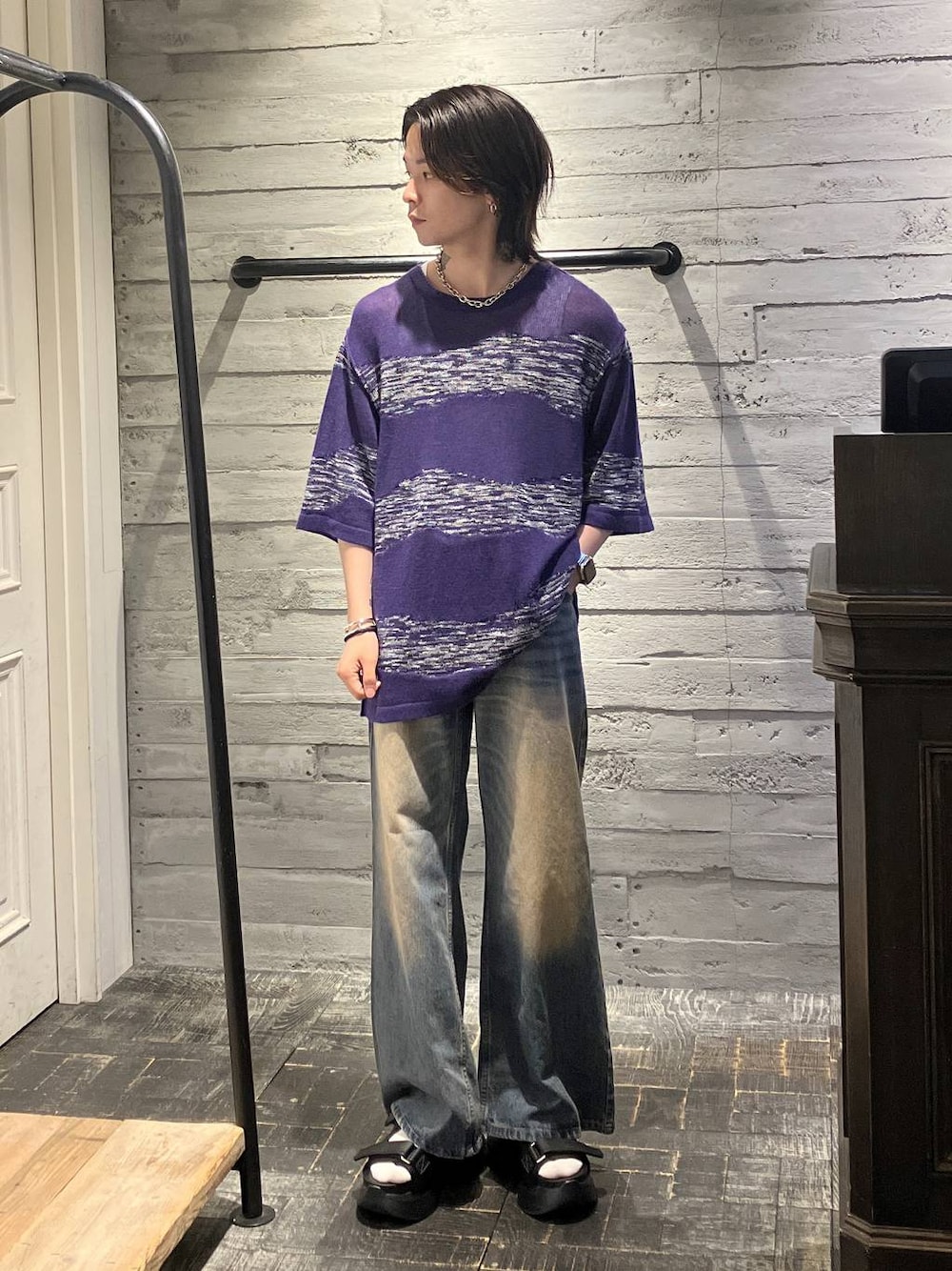 ブラック系のサンダル、ブルー系のデニムパンツ、パープル系のニット/セーターを着用したメンズの夏コーディネートの1枚目の写真
