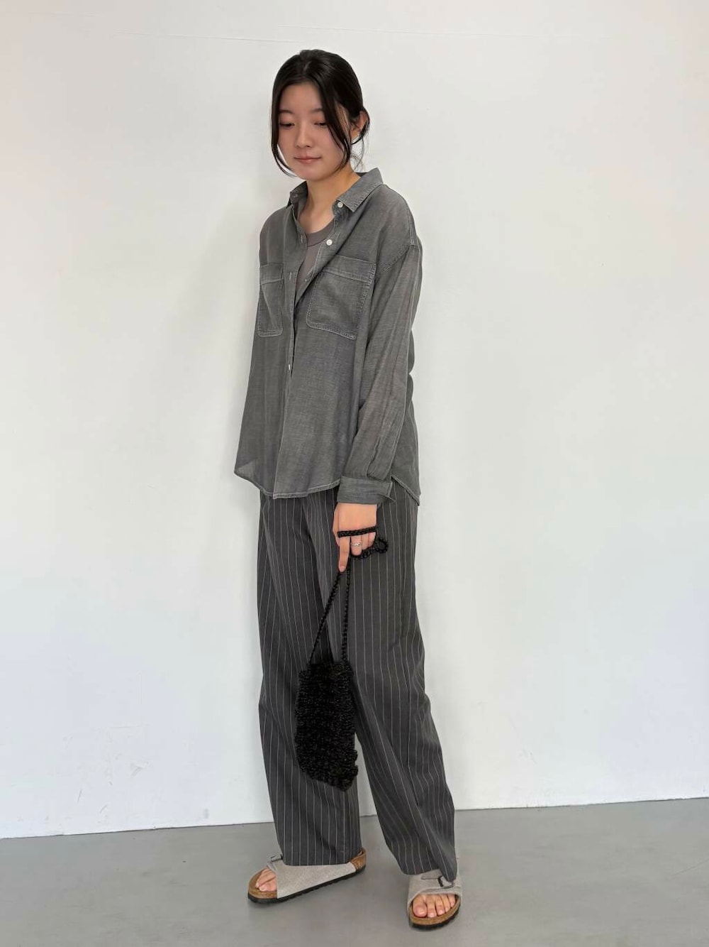 ブラック系のショルダーバッグ、グレー系のその他パンツ、ブラック系のシャツ/ブラウスを着用したレディースの夏コーディネートの1枚目の写真