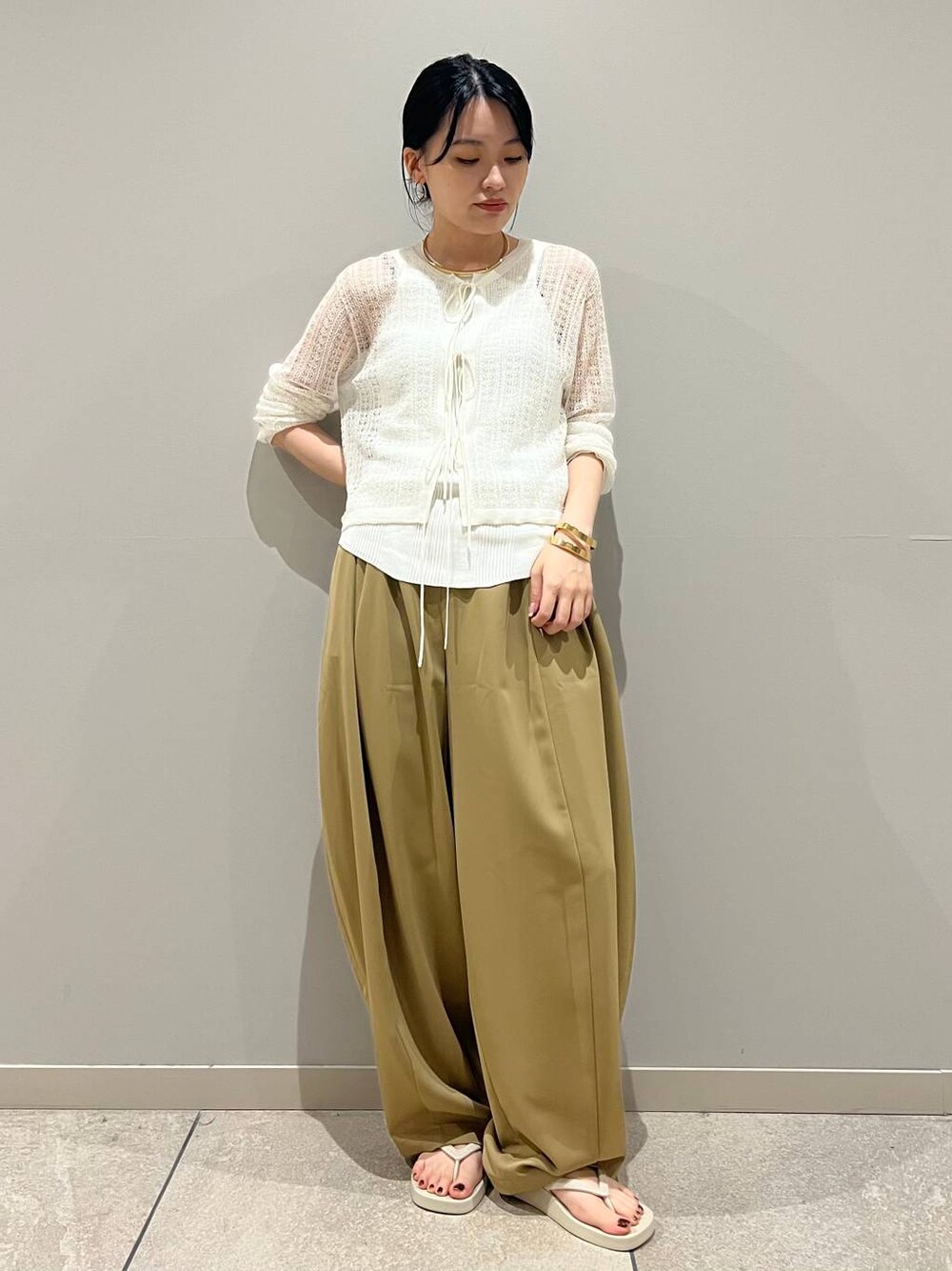 ホワイト系のタンクトップ、ベージュ系のサンダル、イエロー系のその他パンツを着用したレディースの夏コーディネートの1枚目の写真