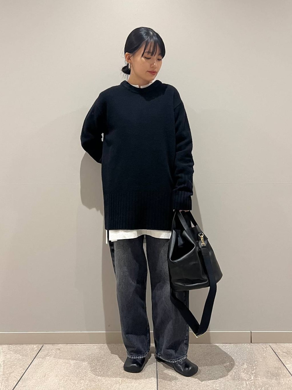 ブラック系のデニムパンツ、ブラック系のショルダーバッグ、ホワイト系のシャツ/ブラウスを着用したレディースの冬コーディネートの1枚目の写真