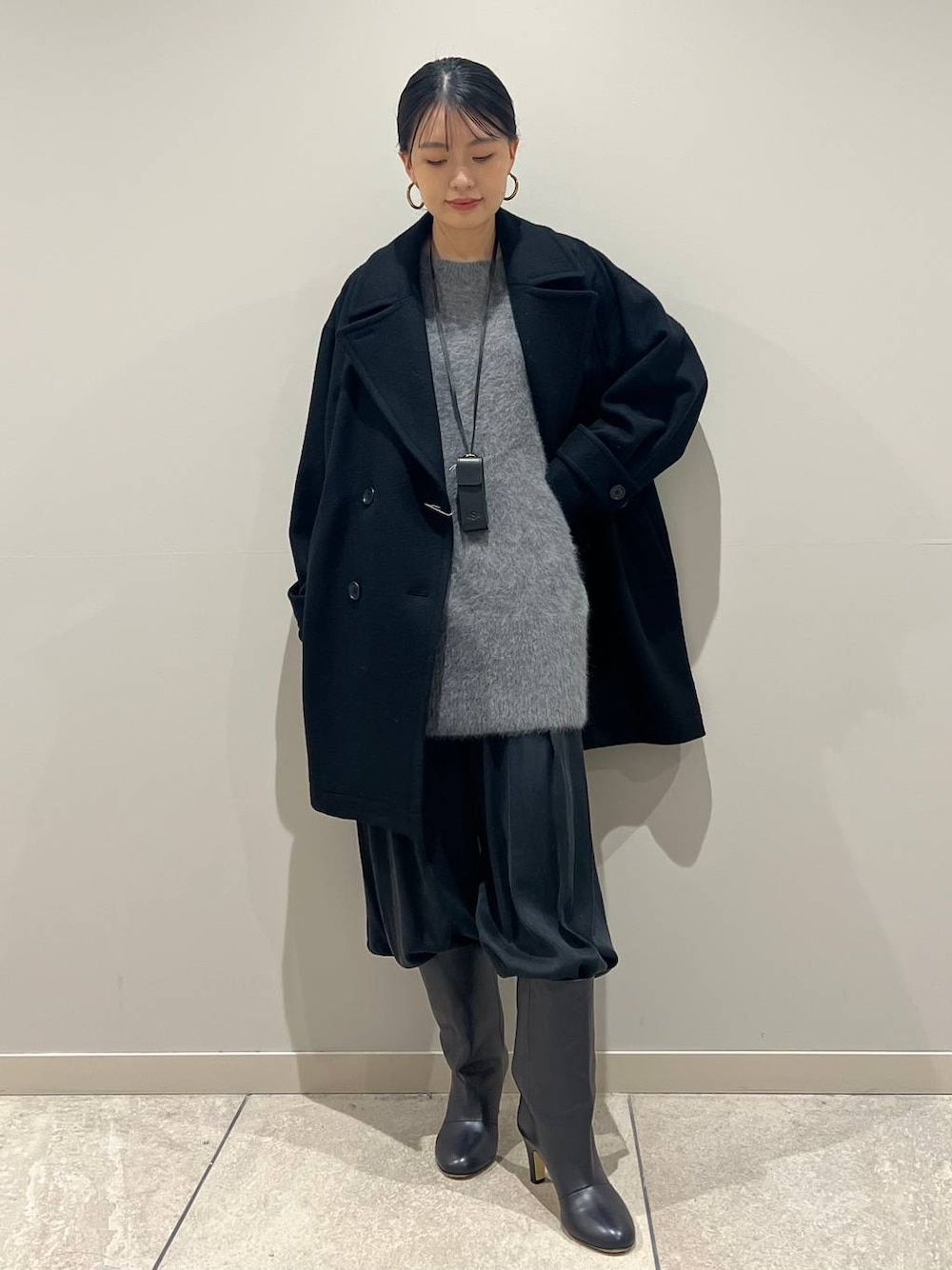 グレー系のニット/セーター、ブラック系のその他パンツ、ブラック系のピーコートを着用したレディースの冬コーディネートの1枚目の写真