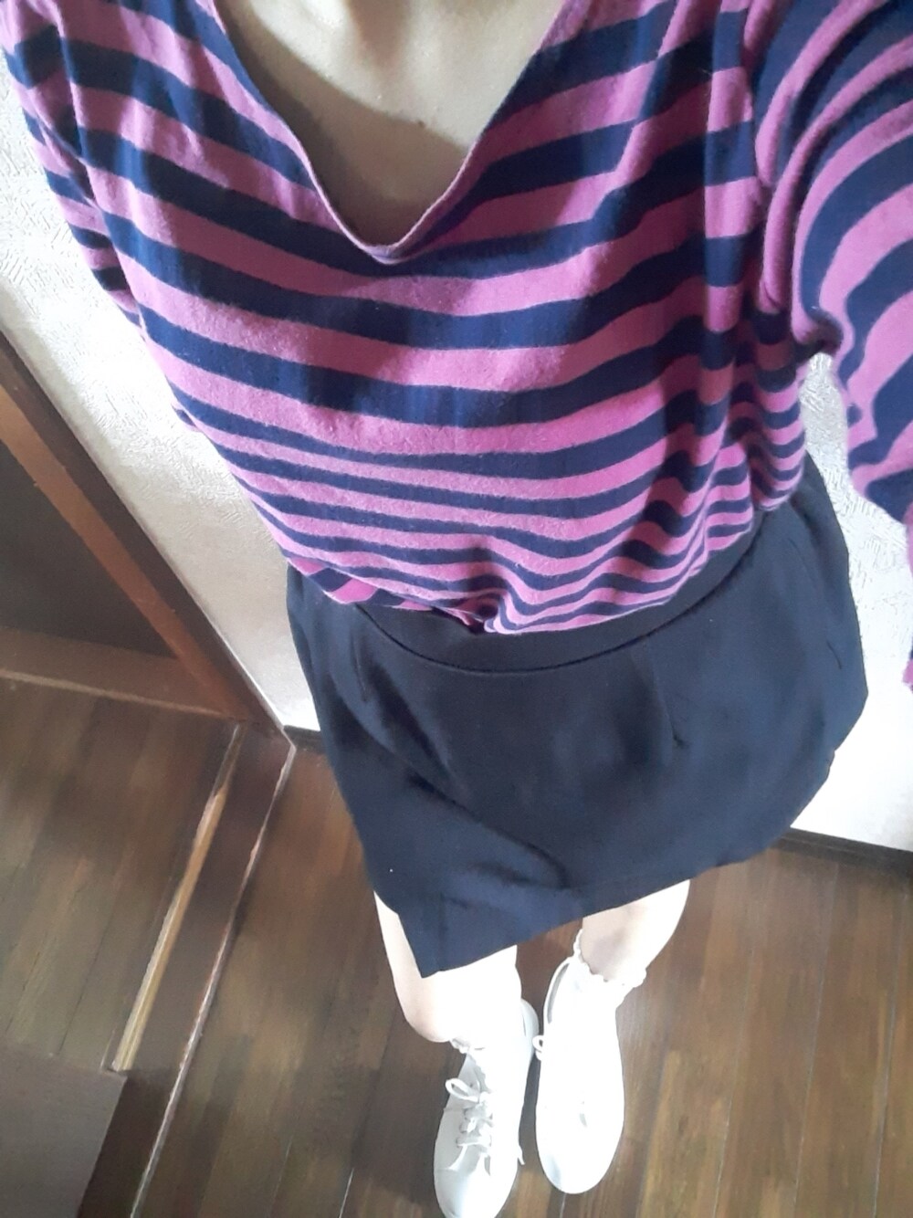 ブラック系のスカート、ホワイト系のスニーカーを着用したレディースの夏コーディネートの1枚目の写真