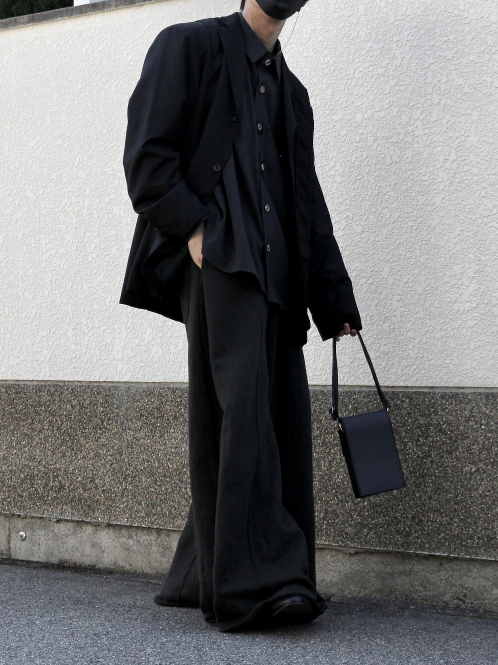 ブラック系のショルダーバッグ、ブラック系のスウェットパンツ、ブラック系のブーツを着用したメンズの秋コーディネートの1枚目の写真