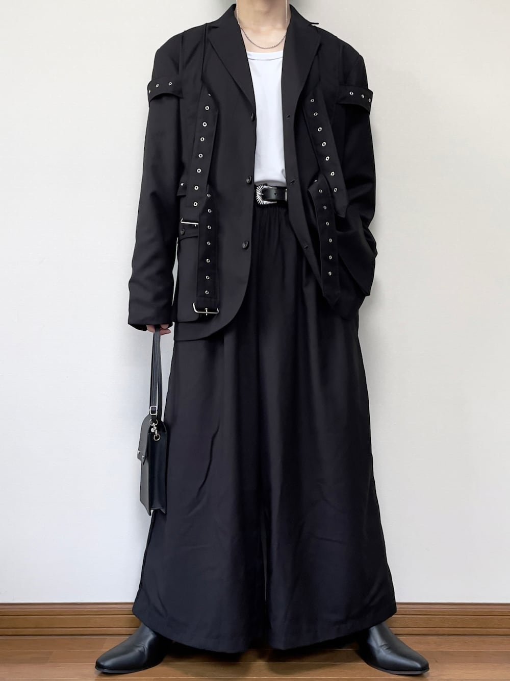 ブラック系のブーツ、ブラック系のその他パンツ、ホワイト系のタンクトップを着用したメンズの夏コーディネートの1枚目の写真