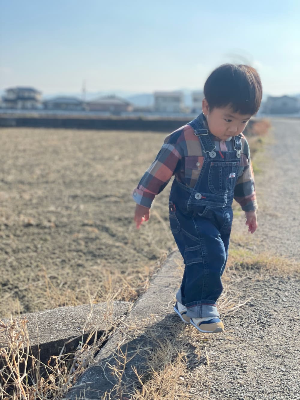 「田舎、私の推しブランド、チェック柄に恋してる、ダブルビー、ブリーズ、おしゃれさんと繋がりたい、２歳1ヶ月、かわいい、男の子、オーバーオール、晴れ、お正月、田んぼ、チェックシャツ、休日スタイル」｜「DOUBLE_Bの【NEW】ミキハウス＆ミズノコラボ ベビーシューズ（スニーカー、ベージュ系）」を使った、蒼さん（キッズ・80cm）の冬コーディネートの1枚目の写真