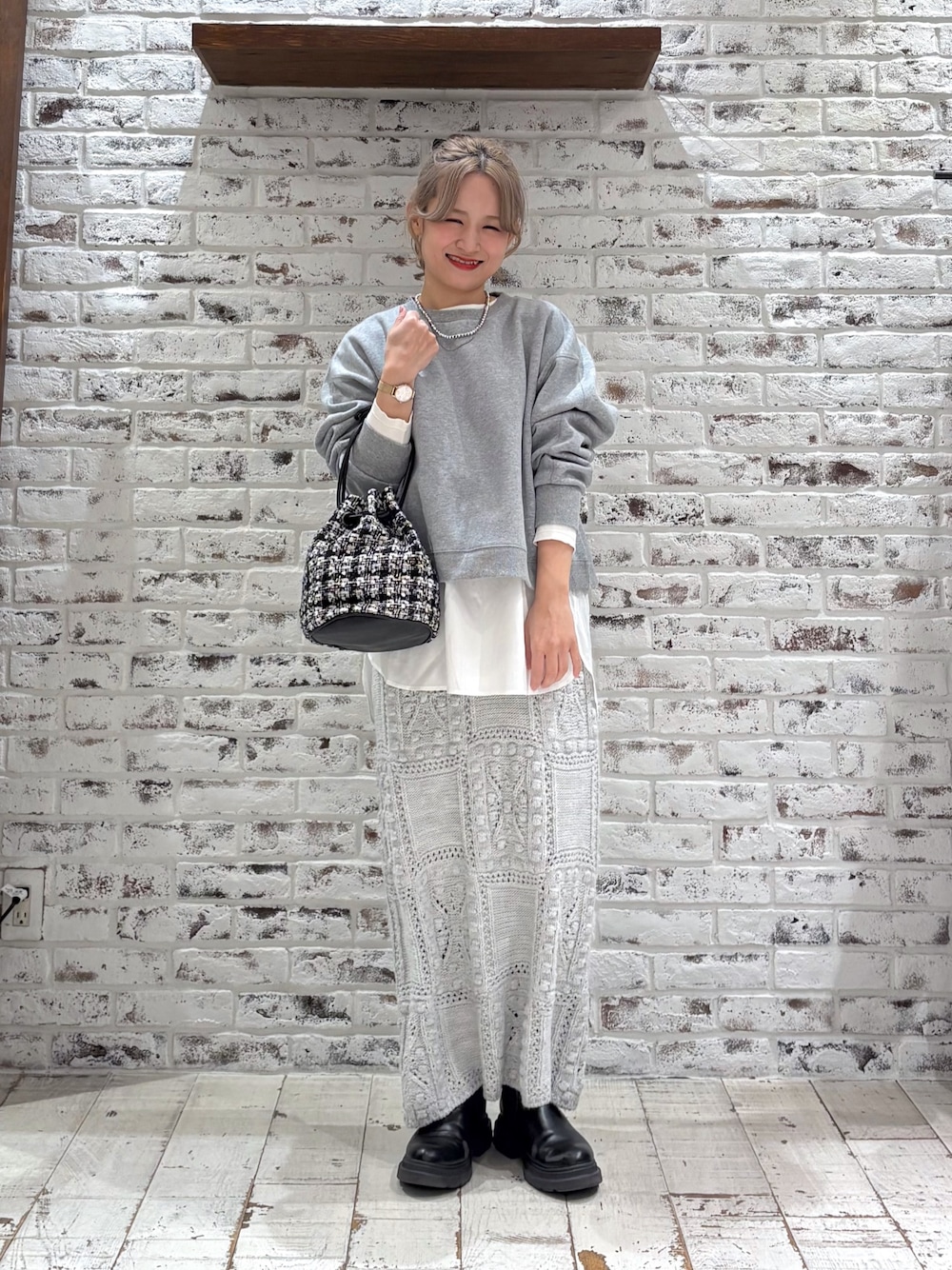 グレー系のスウェット、ホワイト系のシャツ/ブラウス、ベージュ系のスカートを着用したレディースの冬コーディネートの1枚目の写真