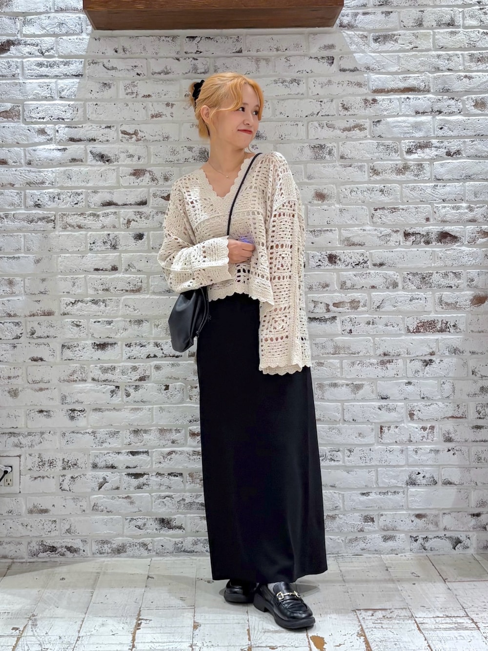 ホワイト系のニット/セーター、ブラック系のスカート、ブラック系のショルダーバッグを着用したレディースの秋コーディネートの1枚目の写真