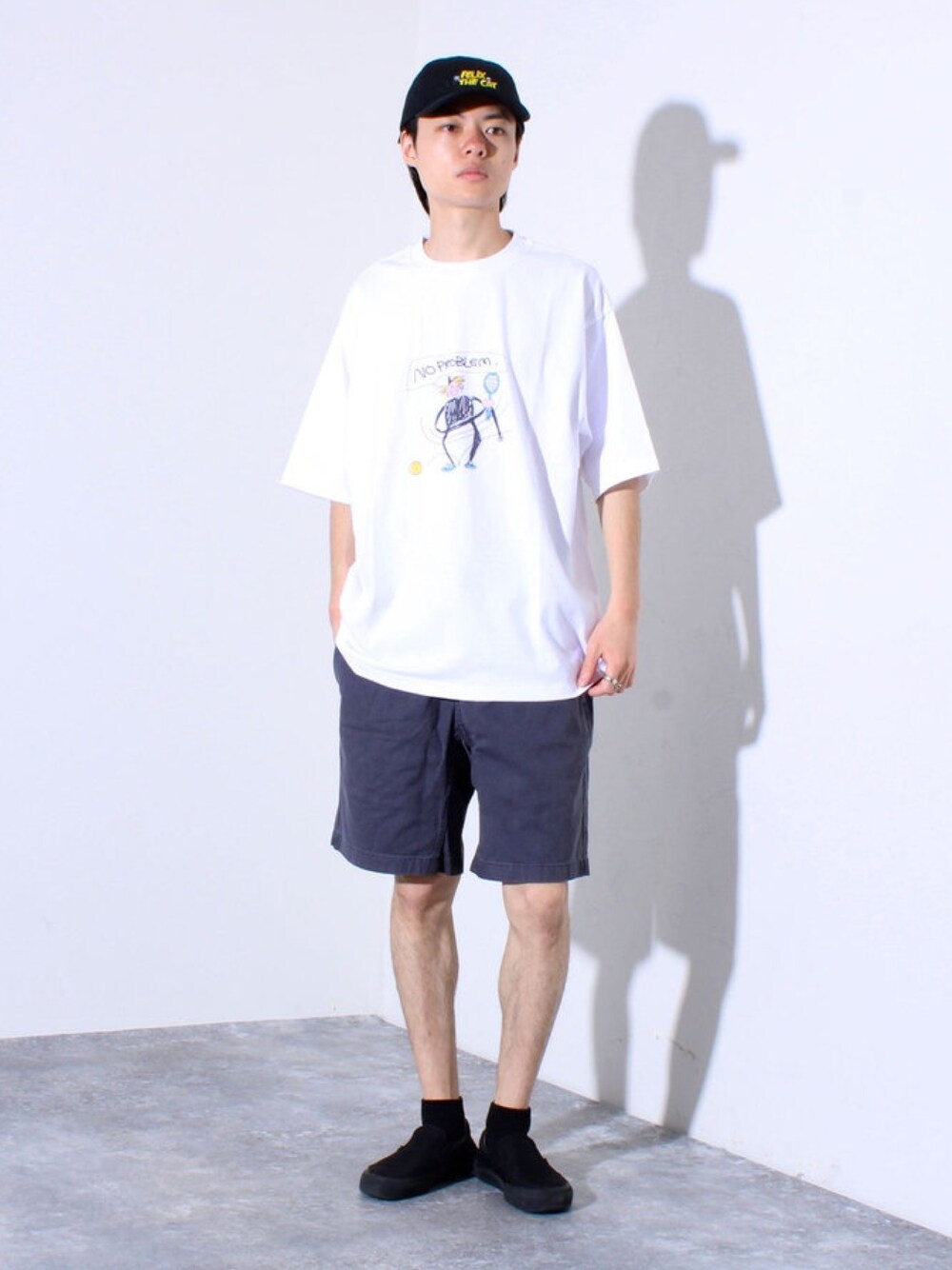 ホワイト系のTシャツ/カットソー、グレー系のその他パンツ、ブラック系のキャップを着用したメンズの春コーディネートの1枚目の写真