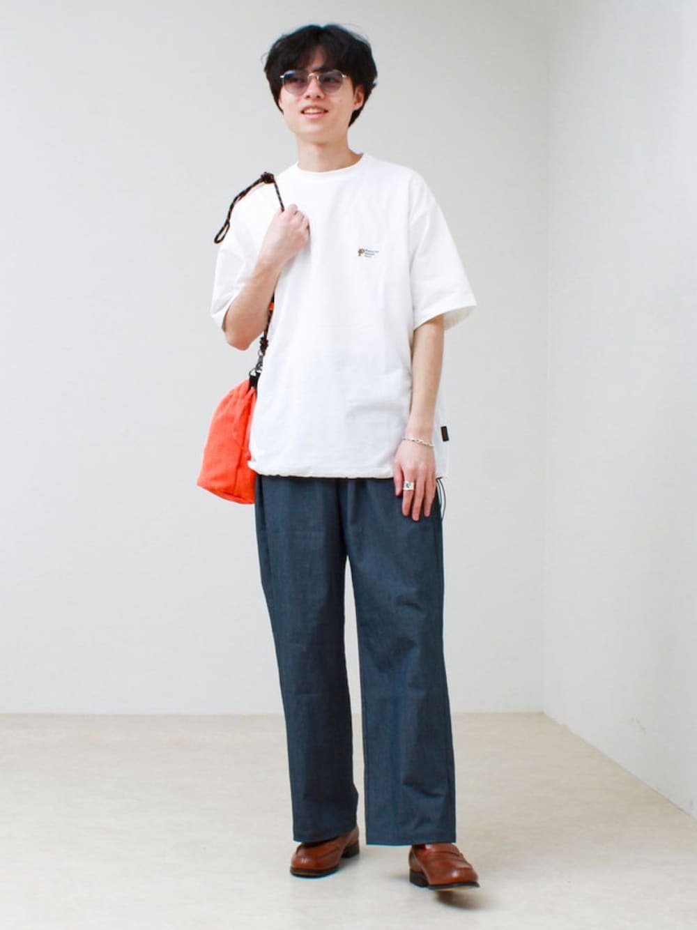 ホワイト系のTシャツ/カットソー、オレンジ系のショルダーバッグ、ブルー系のその他パンツを着用したメンズの春コーディネートの1枚目の写真