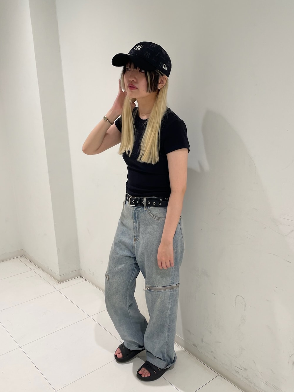 ブラック系のキャップを着用したレディースの夏コーディネートの1枚目の写真