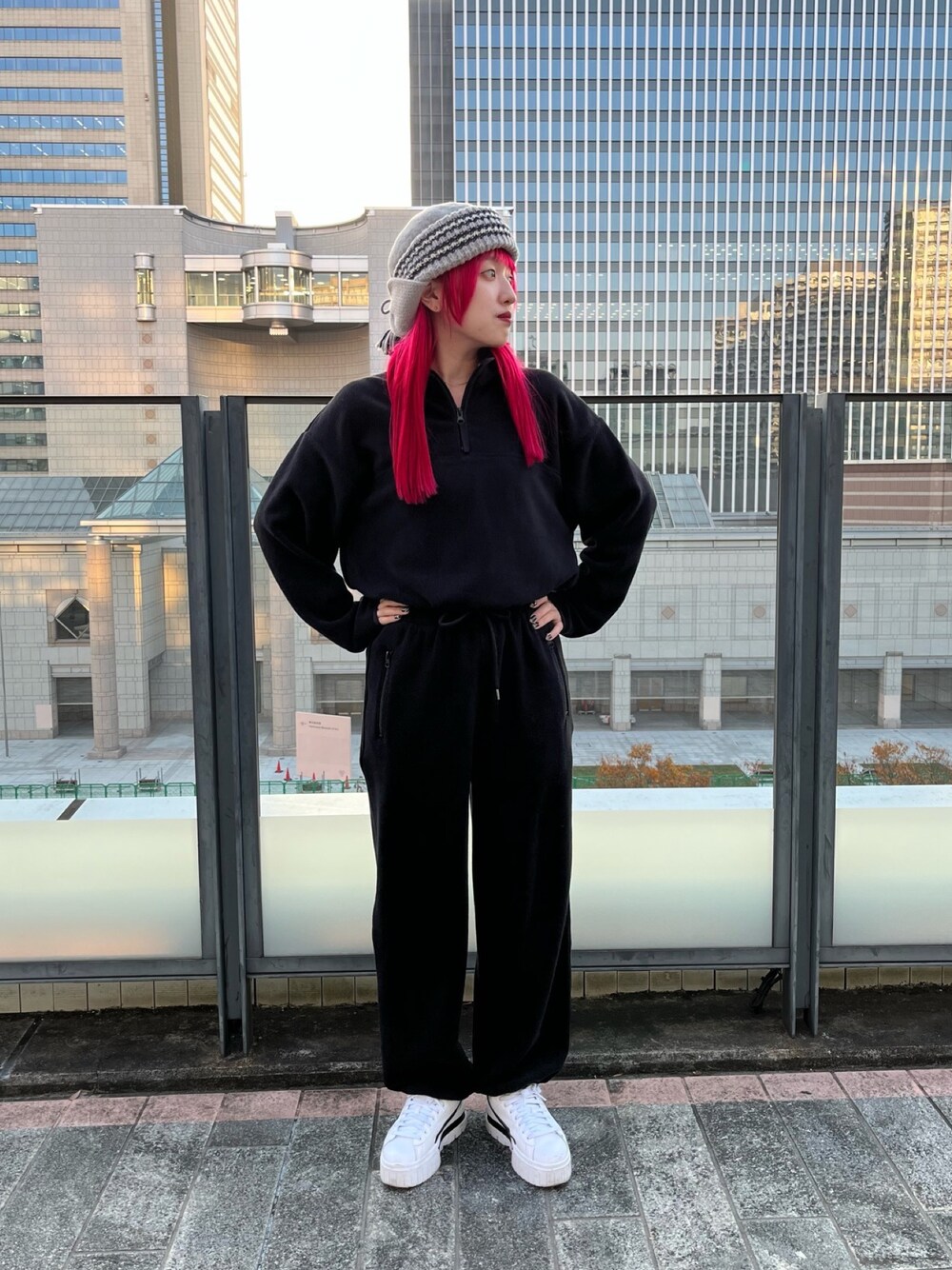 ブラック系のトップス、ブラック系のパンツ、ホワイト系のスニーカーを着用したレディースの冬コーディネートの1枚目の写真