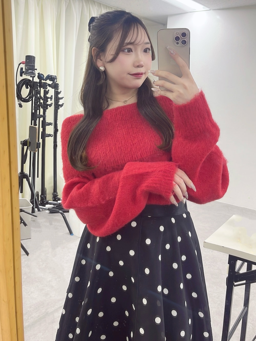 ブルー系のスカート、レッド系のニット/セーター、ゴールド系のネックレスを着用したレディースの秋コーディネートの1枚目の写真