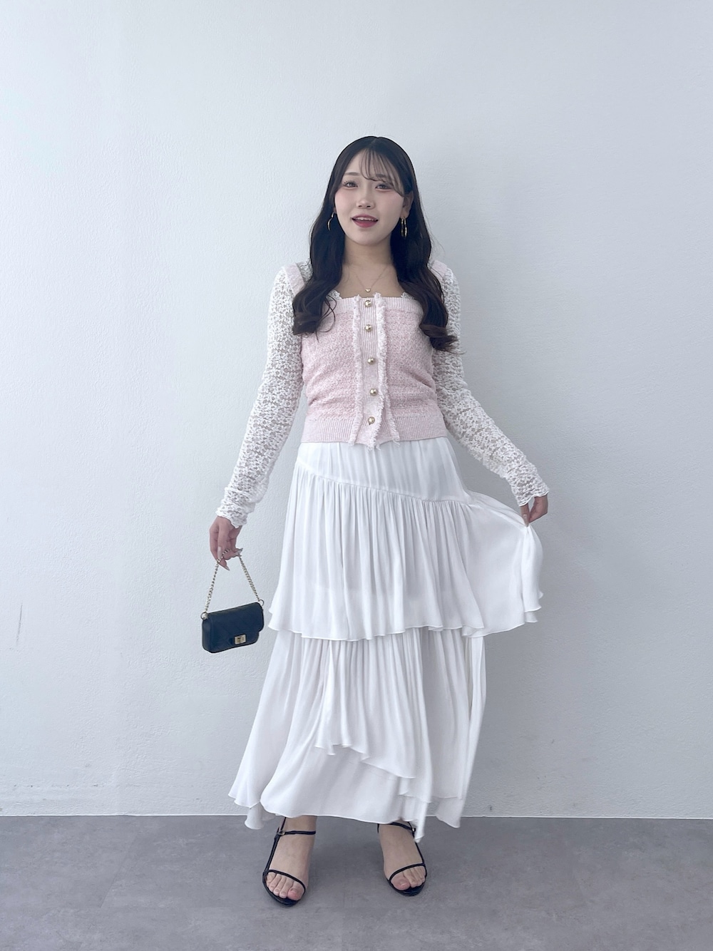 ピンク系のニット/セーター、ホワイト系のTシャツ/カットソー、ホワイト系のスカートを着用したレディースの冬コーディネートの1枚目の写真