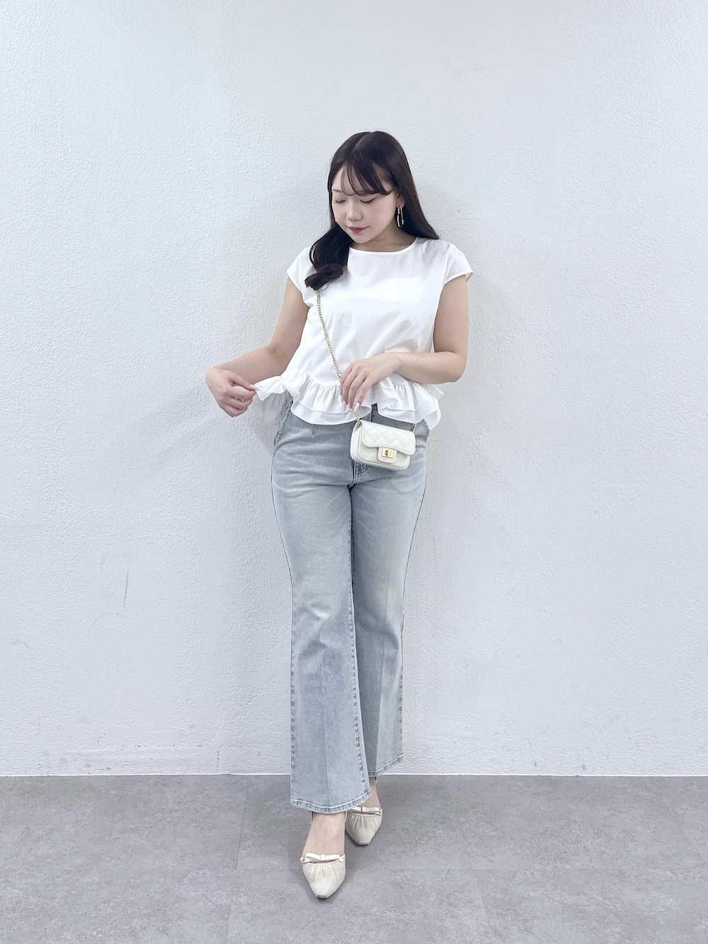 ホワイト系のシャツ/ブラウス、ホワイト系のトートバッグ、ブルー系のデニムパンツを着用したレディースの春コーディネートの1枚目の写真