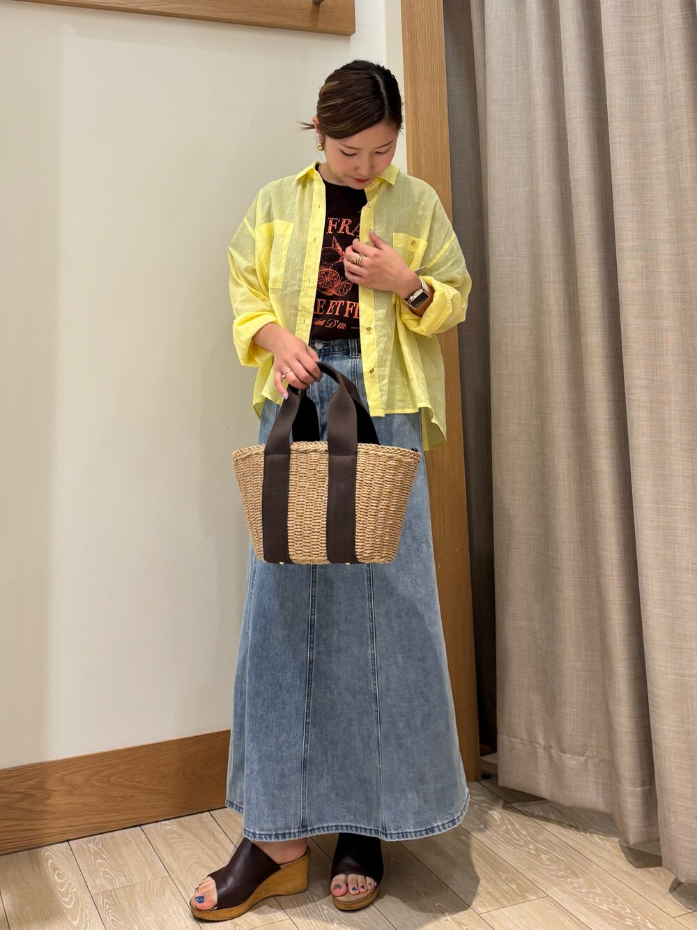 ブラウン系のTシャツ/カットソー、イエロー系のシャツ/ブラウス、ブルー系のデニムスカートを着用したレディースの夏コーディネートの1枚目の写真