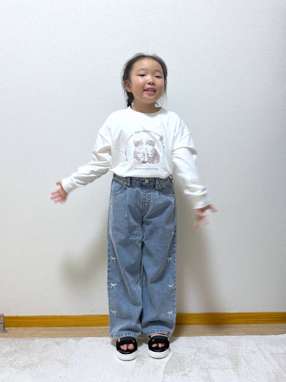 ブルー系のデニムパンツ、ブラック系のサンダル、ホワイト系のTシャツ/カットソーを着用したキッズの秋コーディネートの1枚目の写真