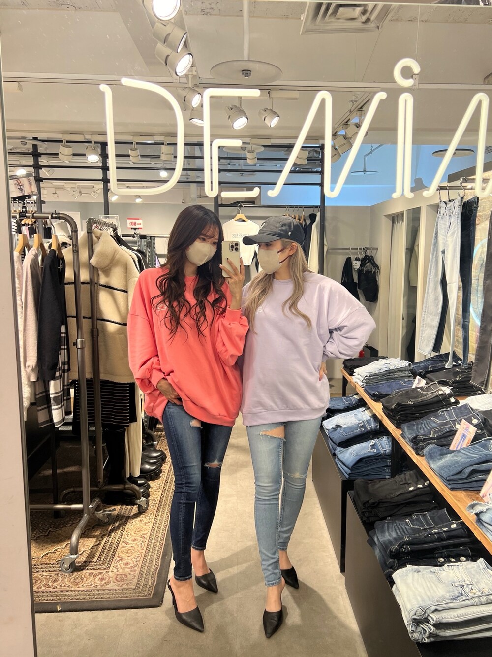 ピンク系のスウェット、ブルー系のデニムパンツ、ブラック系のパンプスを着用したレディースの冬コーディネートの1枚目の写真