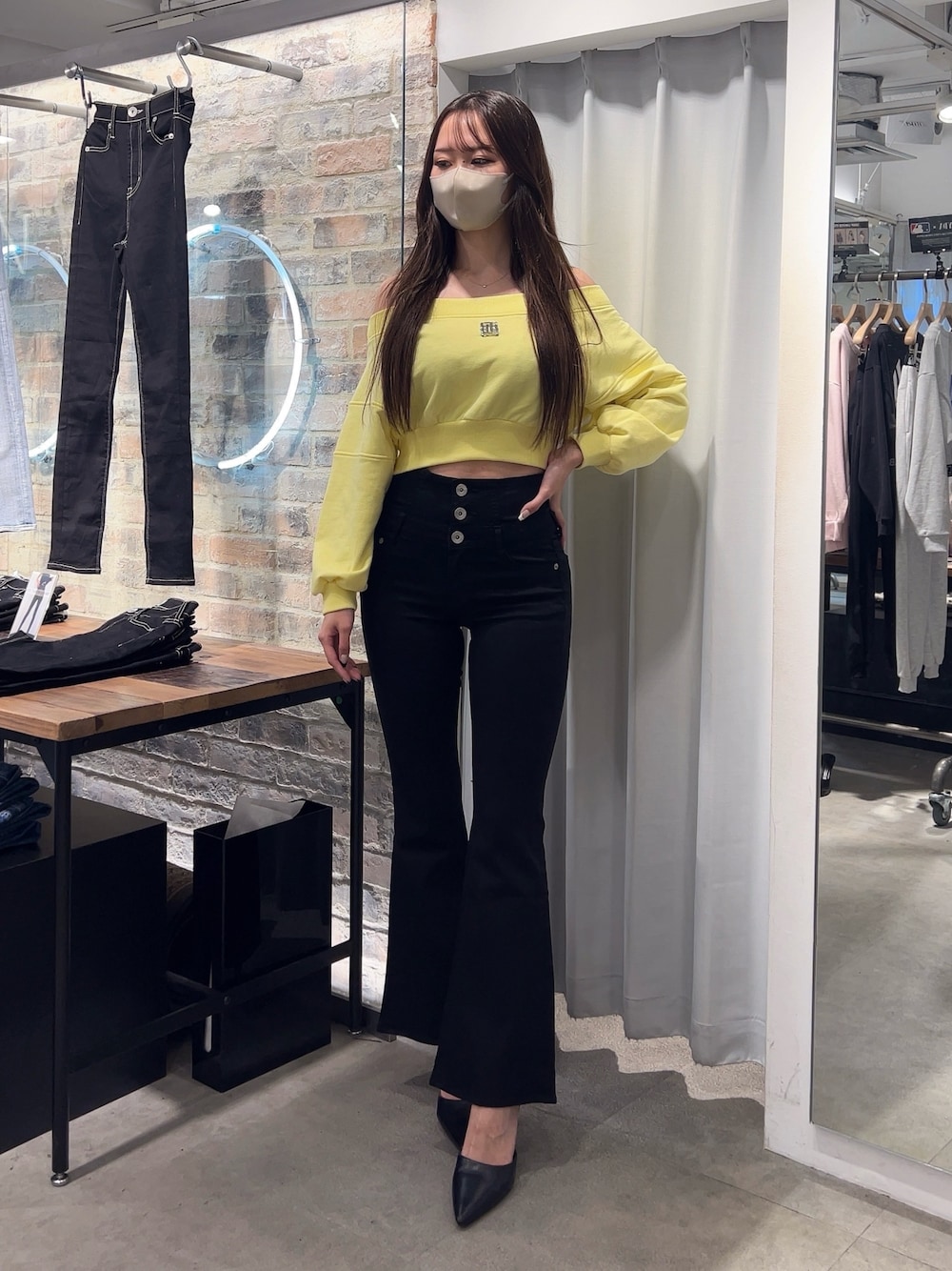 イエロー系のスウェット、ブラック系のデニムパンツ、ブラック系のパンプスを着用したレディースの冬コーディネートの1枚目の写真