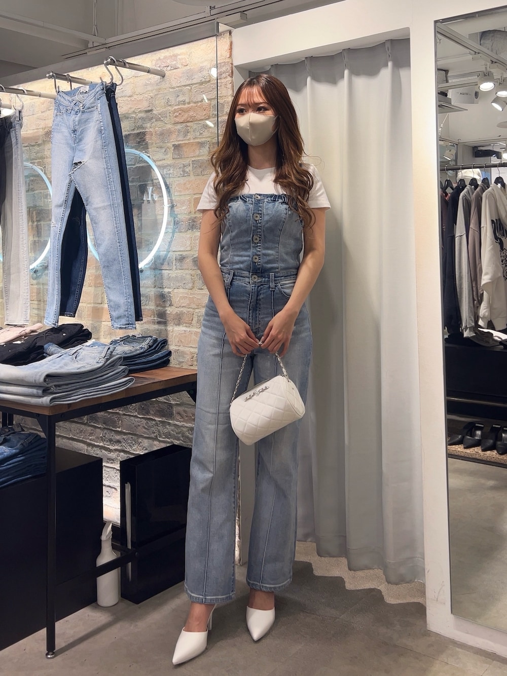 ブルー系のサロペット/オーバーオール、ホワイト系のTシャツ/カットソー、ホワイト系のパンプスを着用したレディースの冬コーディネートの1枚目の写真