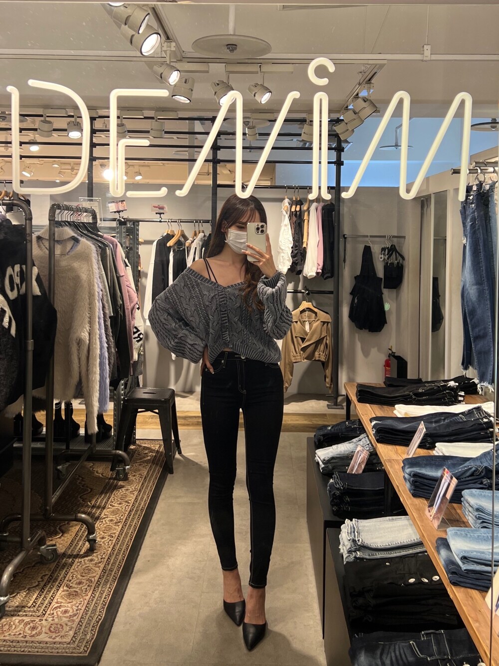 ブルー系のニット/セーター、ブラック系のキャミソール、ブラック系のデニムパンツを着用したレディースの秋コーディネートの1枚目の写真