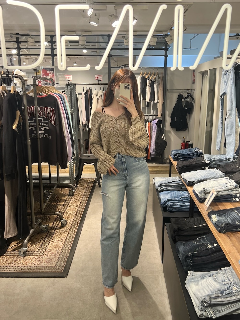 ブルー系のニット/セーター、ホワイト系のキャミソール、ブルー系のデニムパンツを着用したレディースの冬コーディネートの1枚目の写真