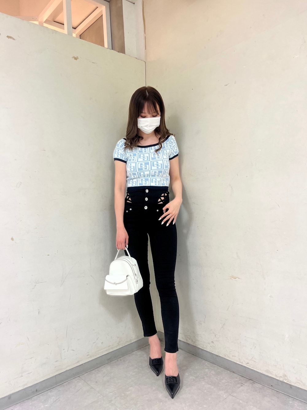 ブルー系のニット/セーター、ホワイト系のバックパック/リュック、ブラック系のパンプスを着用したレディースの春コーディネートの1枚目の写真