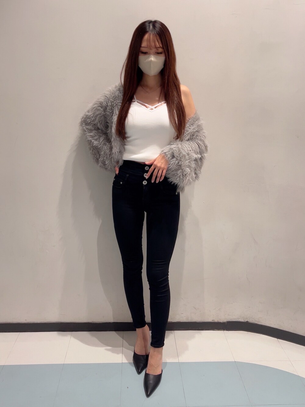 グレー系のカーディガン/ボレロ、ホワイト系のキャミソール、ブラック系のデニムパンツを着用したレディースの秋コーディネートの1枚目の写真